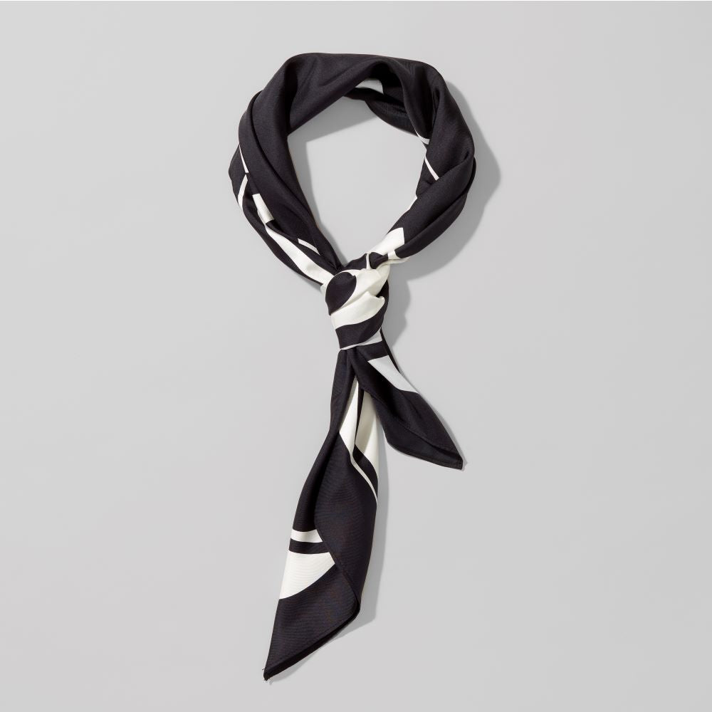 Folded 100% silk twill origin scarf by Carol Bove. Measures 36" x 36".