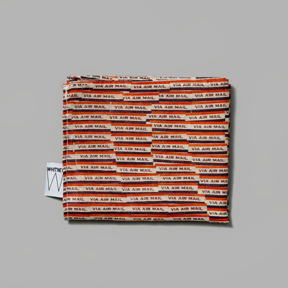Folded 100% lawn cotton handkerchief featuring Yayoi Kusama's Air Mail Stickers. Measures 15.75" x 15.75".