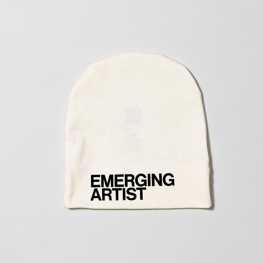 100% certified organic cotton white baby hat with Emerging Artist in black text