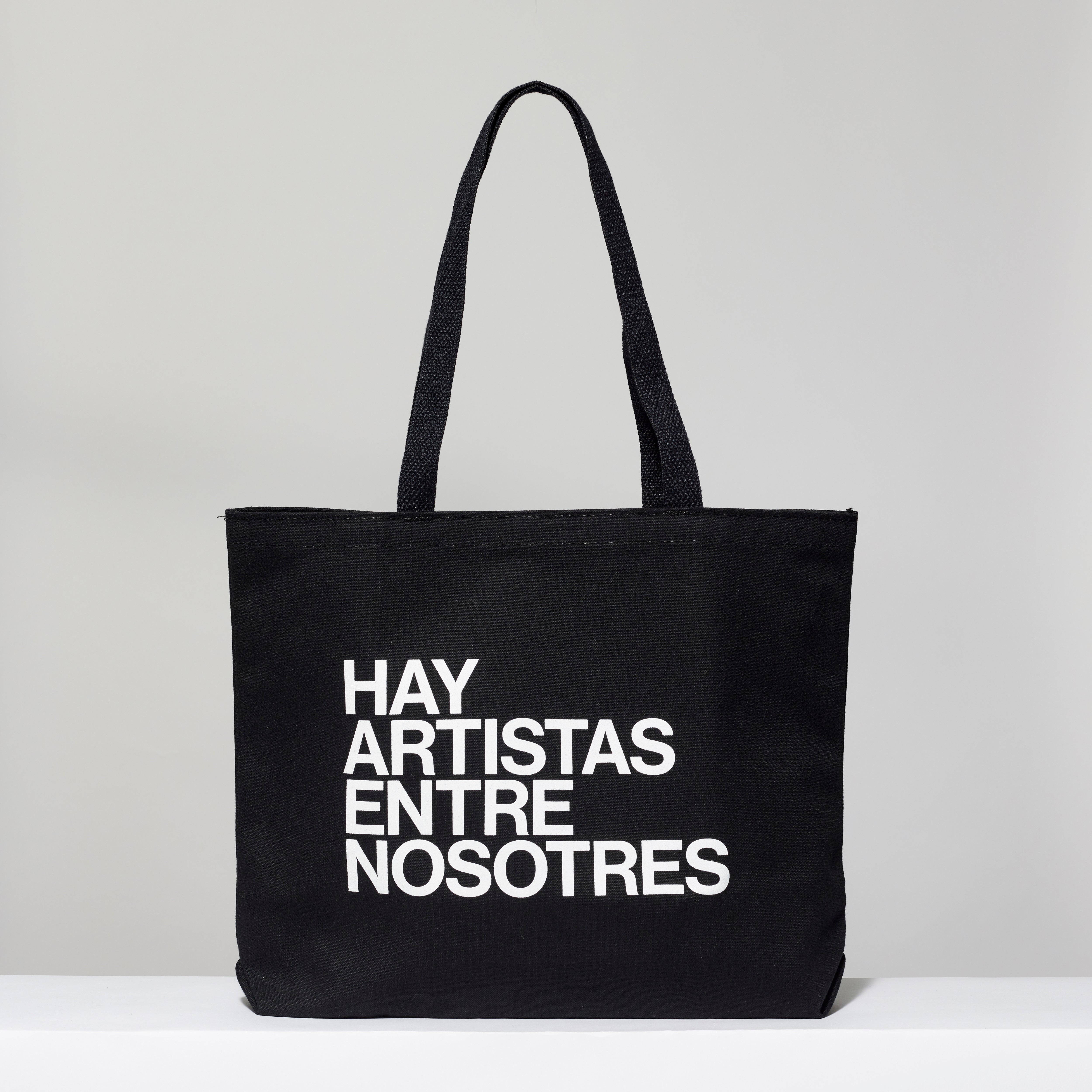 100% cotton black tote with Hay Artistas Entre Nosotres text in white. Measures 18" x 14". 3.5" gusset, 11" handles.