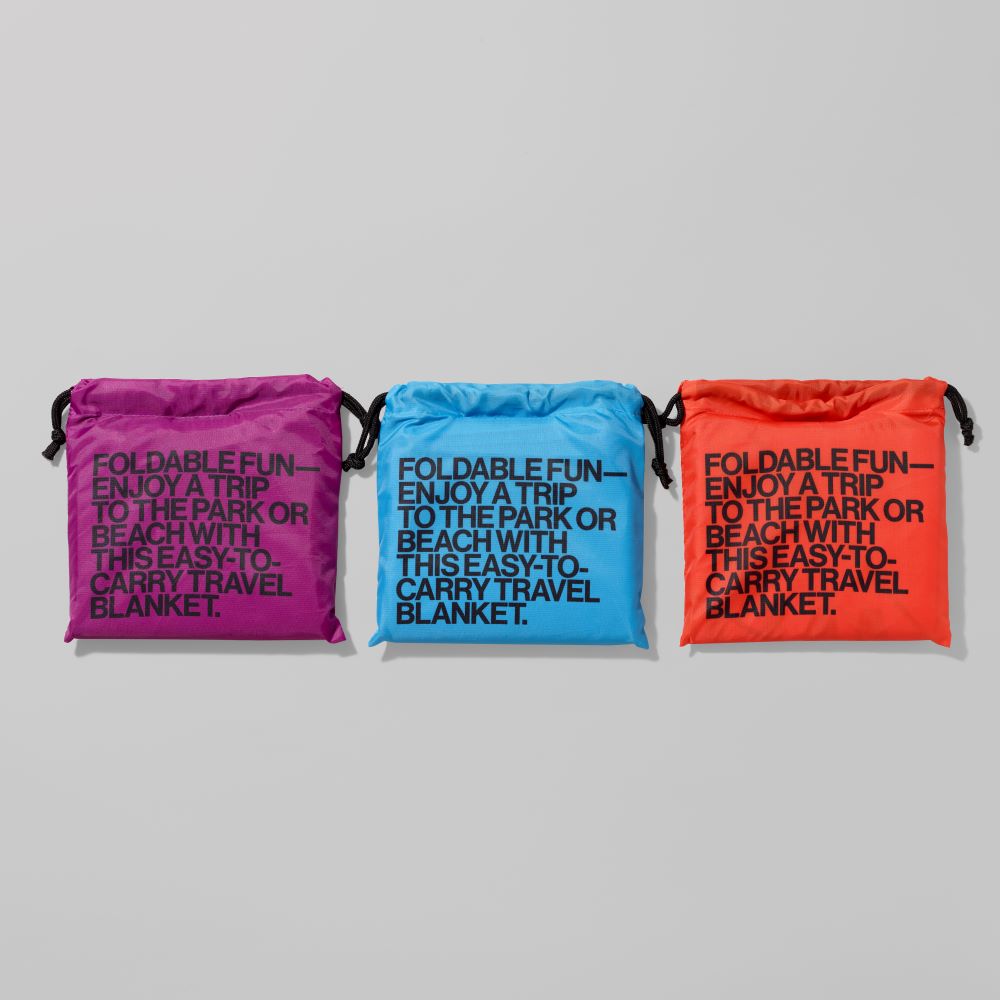 Purple, Blue, and Orange pouches containing ripstop polyester Whitney travel blankets that measure 59" x 59"