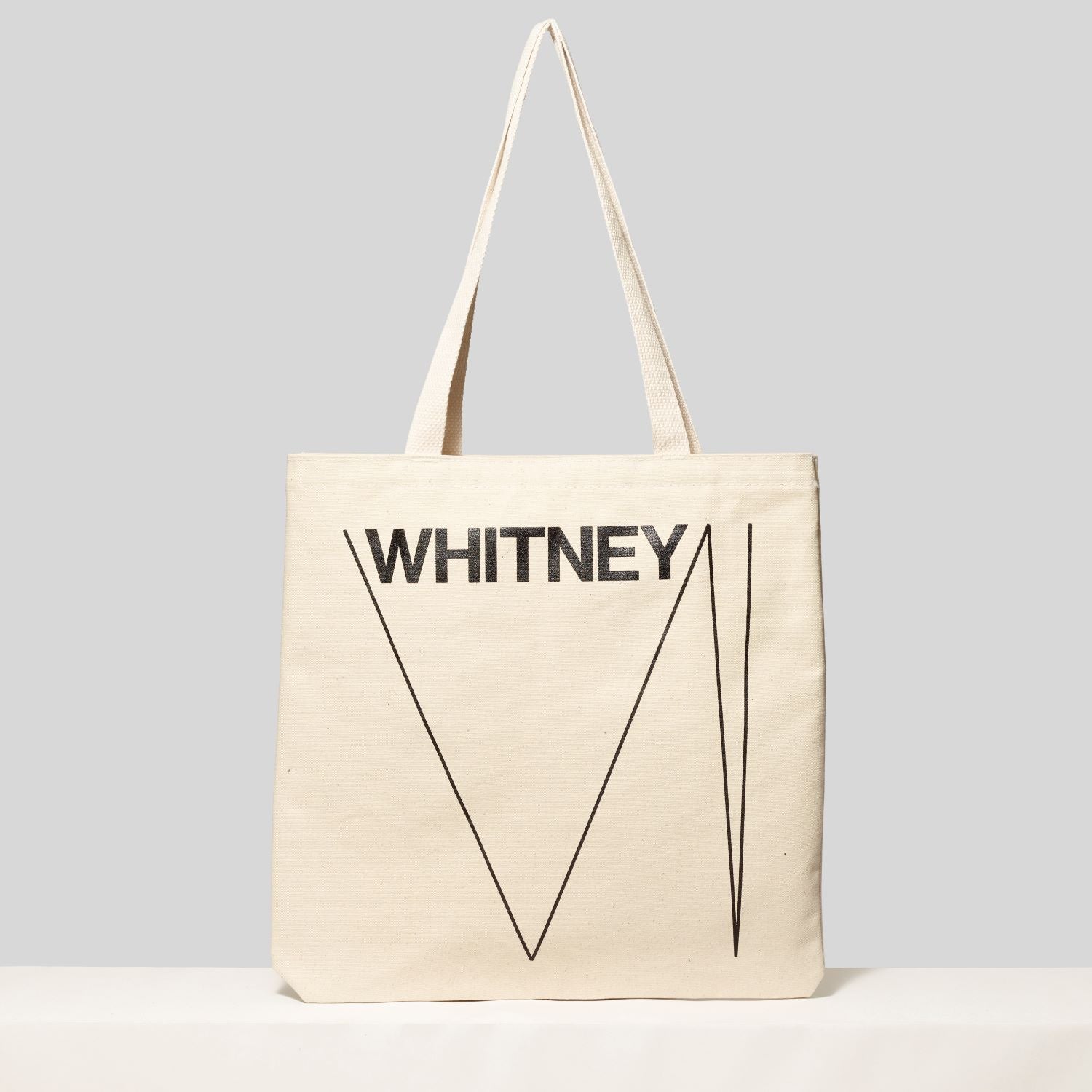 Back view of the cotton canvas tote with Whitney and the W logo in black text. Measures Cotton canvas tote featuring an artwork by Edward Hopper and Hopper's New York in black text. Measures 13.75" H x 13" L