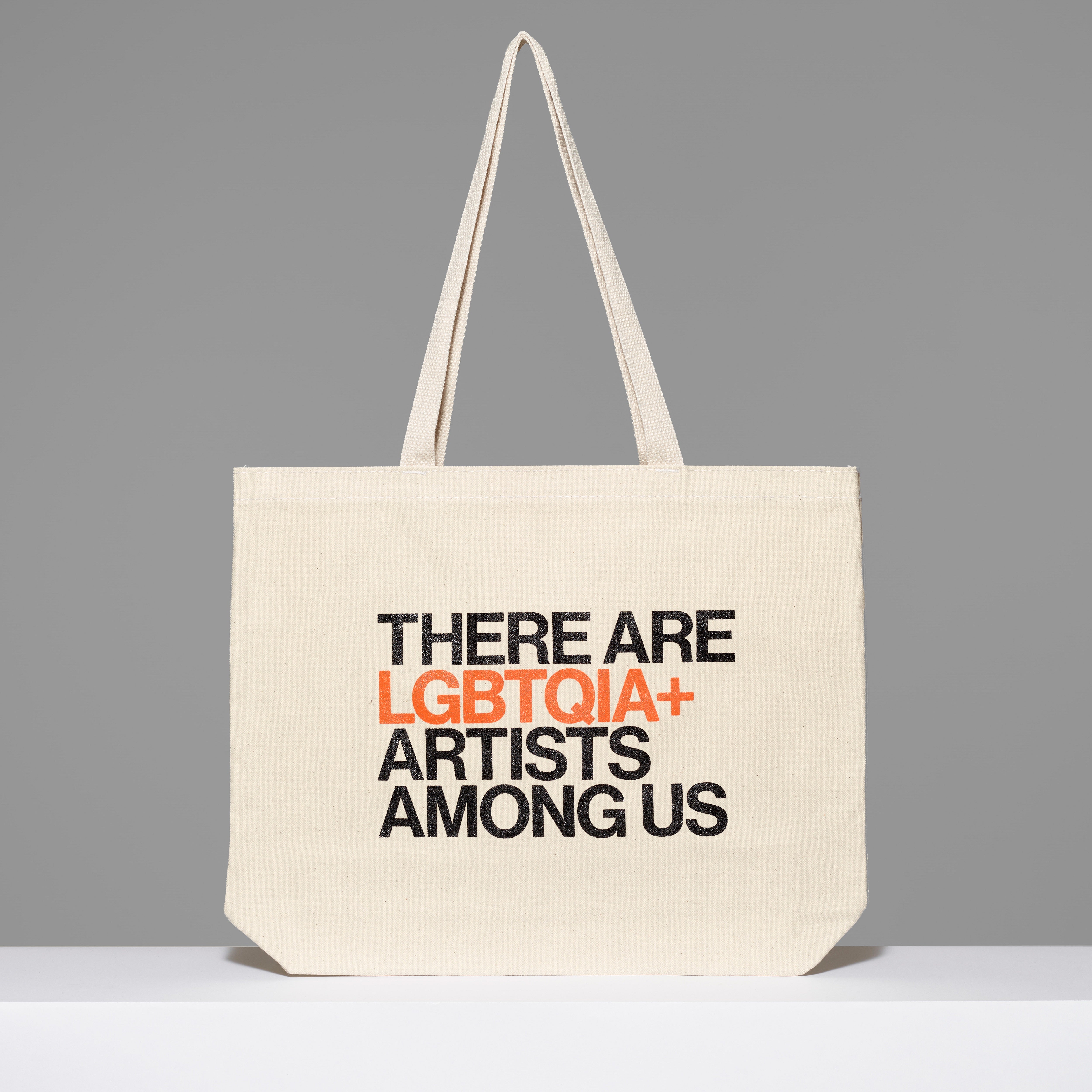 100% cotton There Are LGBTQIA+ Artists Among Us Tote with black and orange text. Measures 18" x 14". 3.5" gusset, 11" handles.