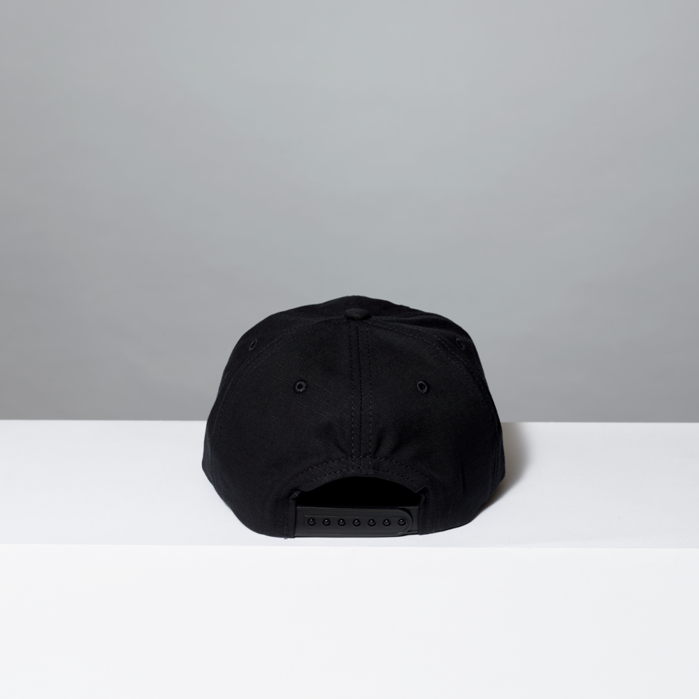 Black cap on a white surface with a gray background