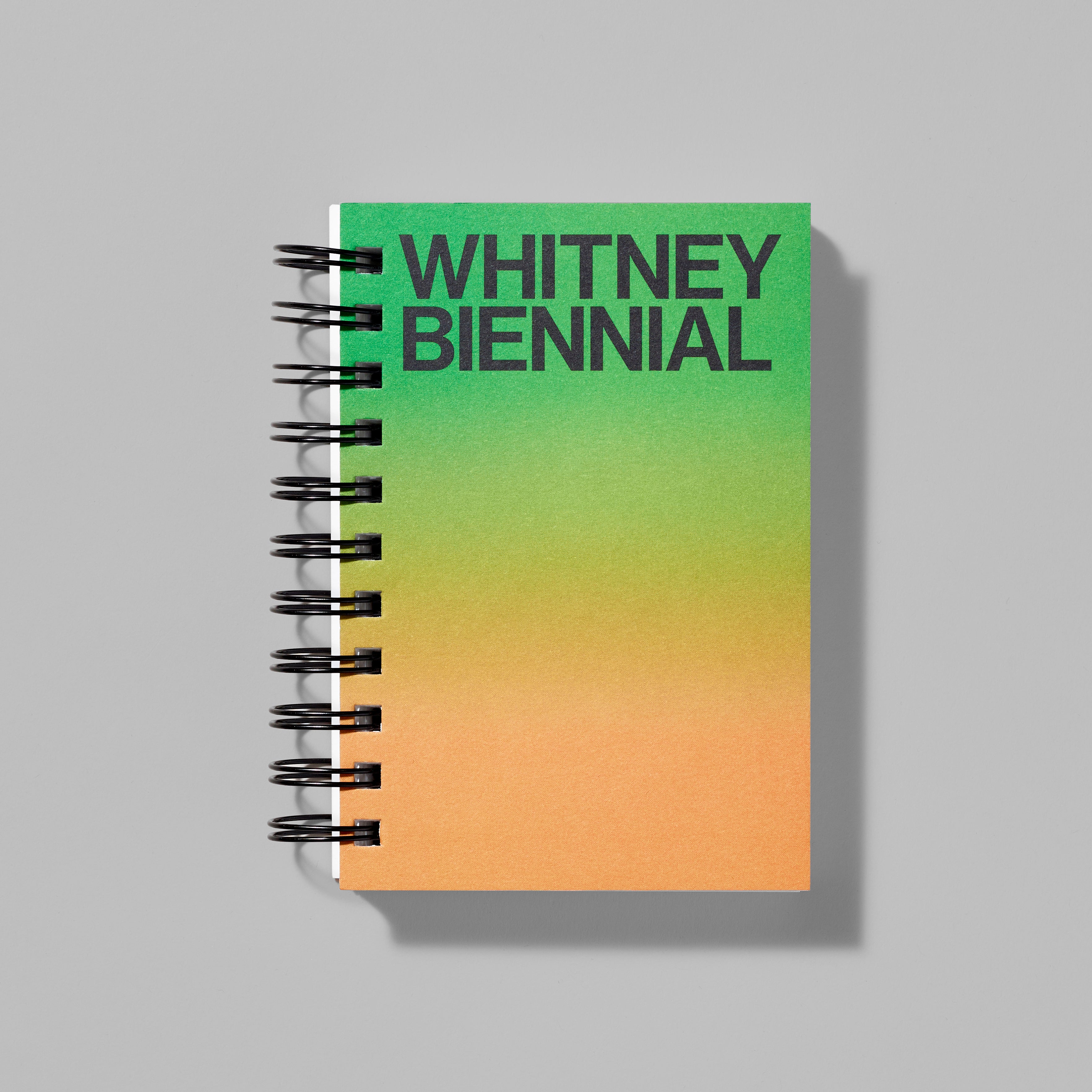Green and orange gradient spiral notebook featuring Whitney Biennial in black text