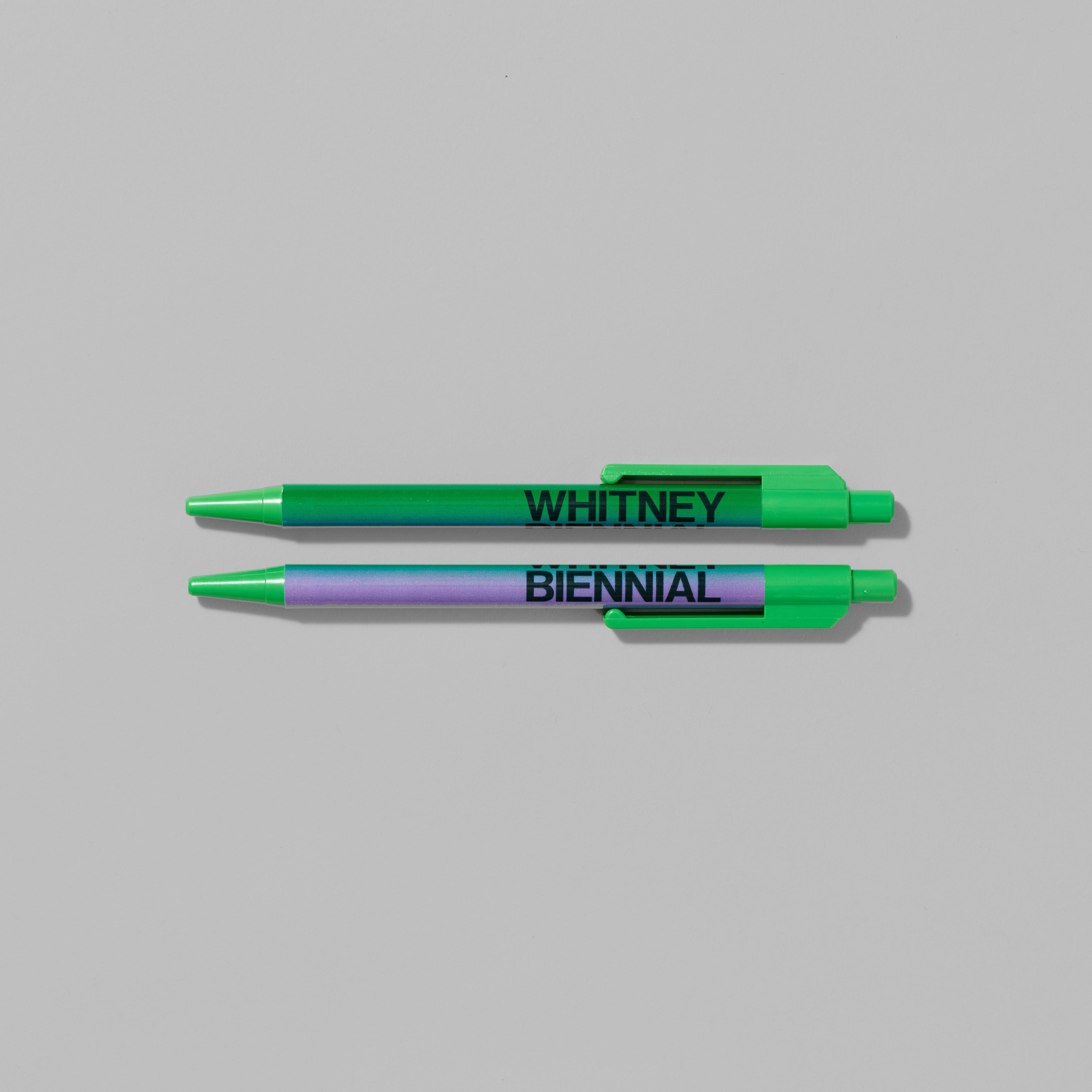 Set of two Whitney Biennial ballpoint pens featuring gradient color combinations. Each measures 0.75" x 6"