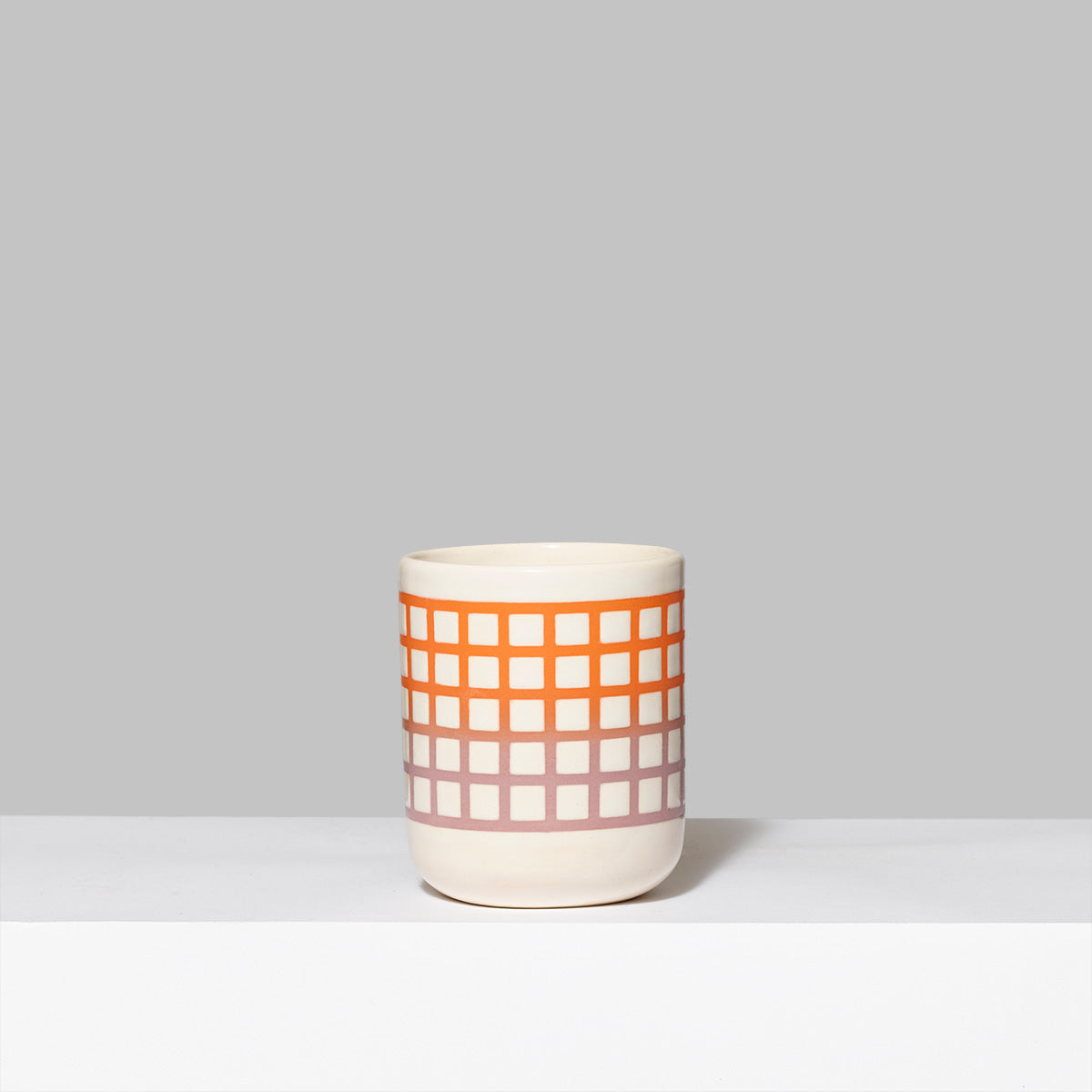 Handmade stoneware and glaze Biennial tumbler in purple and orange. Measures 3" L x 3" W x 3.5" H