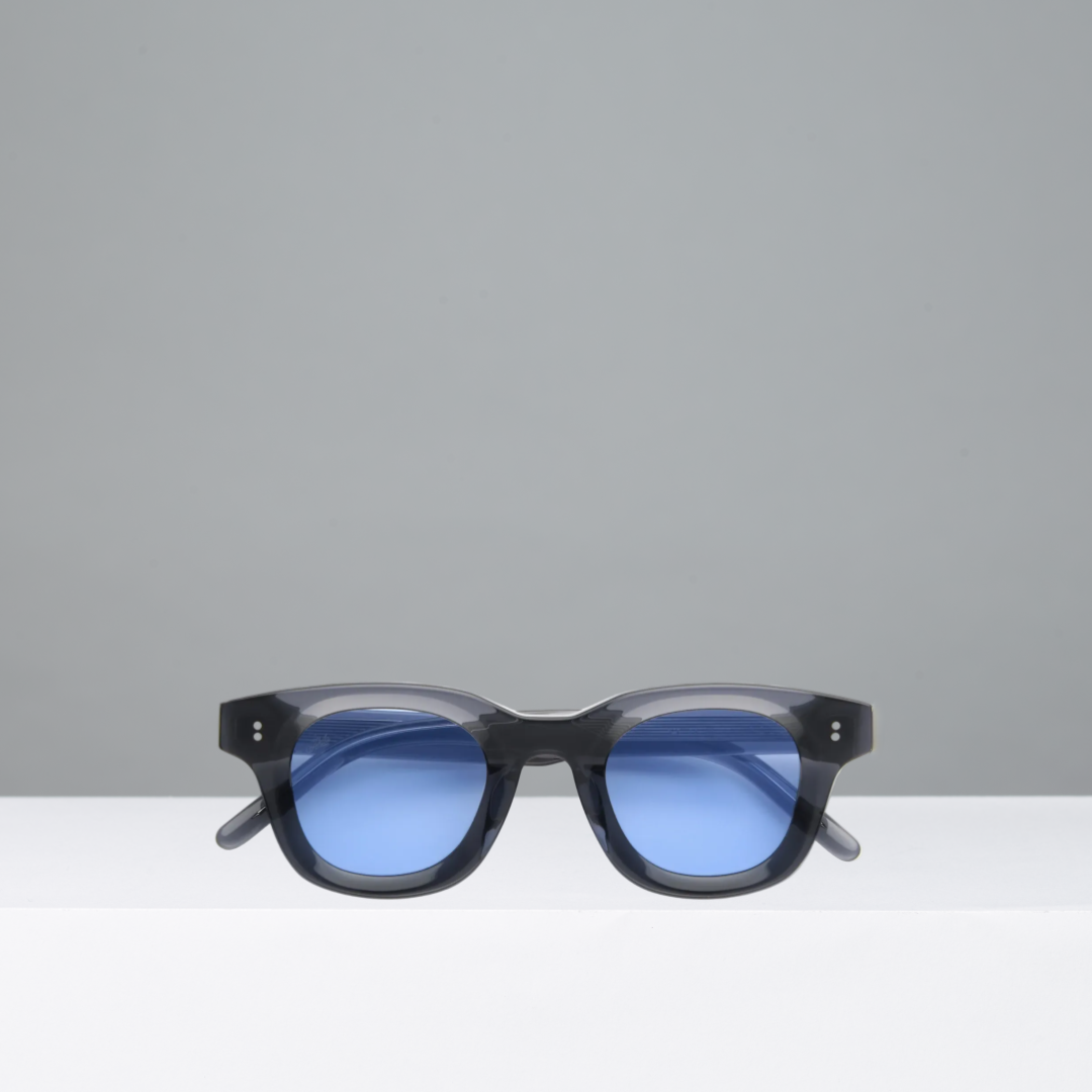 Black sunglasses with blue lenses on a gray background