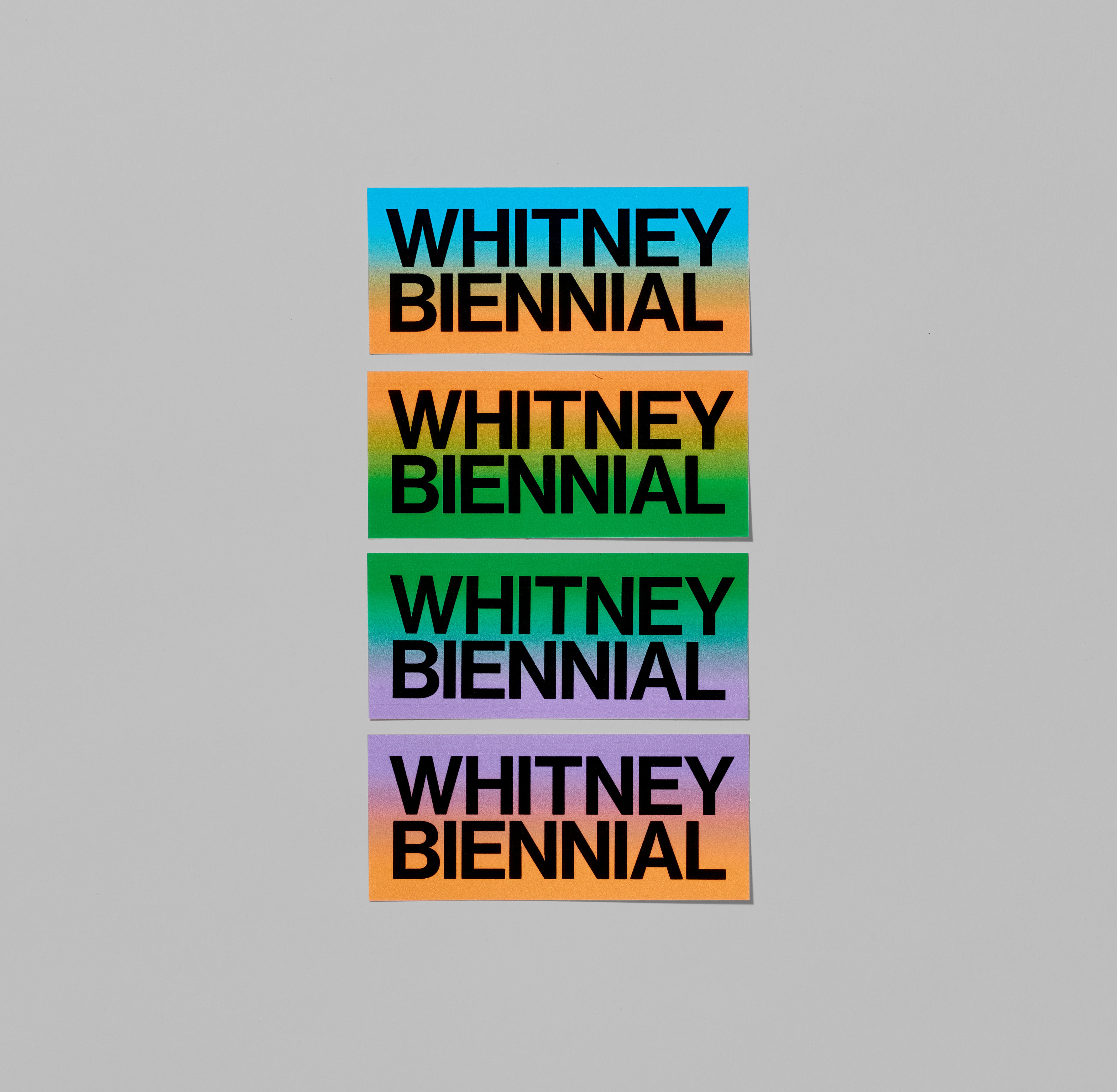 Set of four Whitney Biennial Stickers featuring gradient color combinations. Each measures 1.75" x 4"
