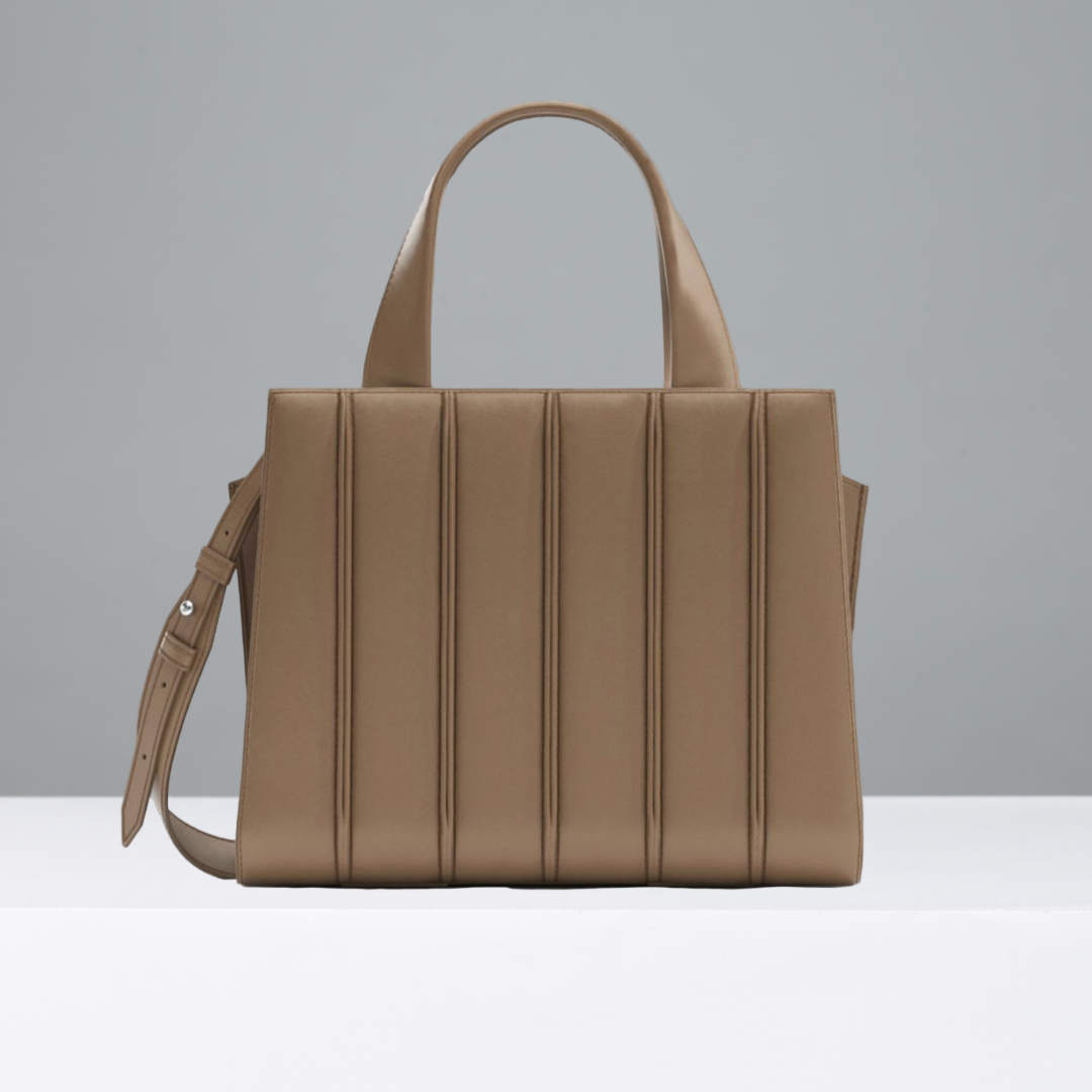 Camel handbag with a shoulder strap on a gray background