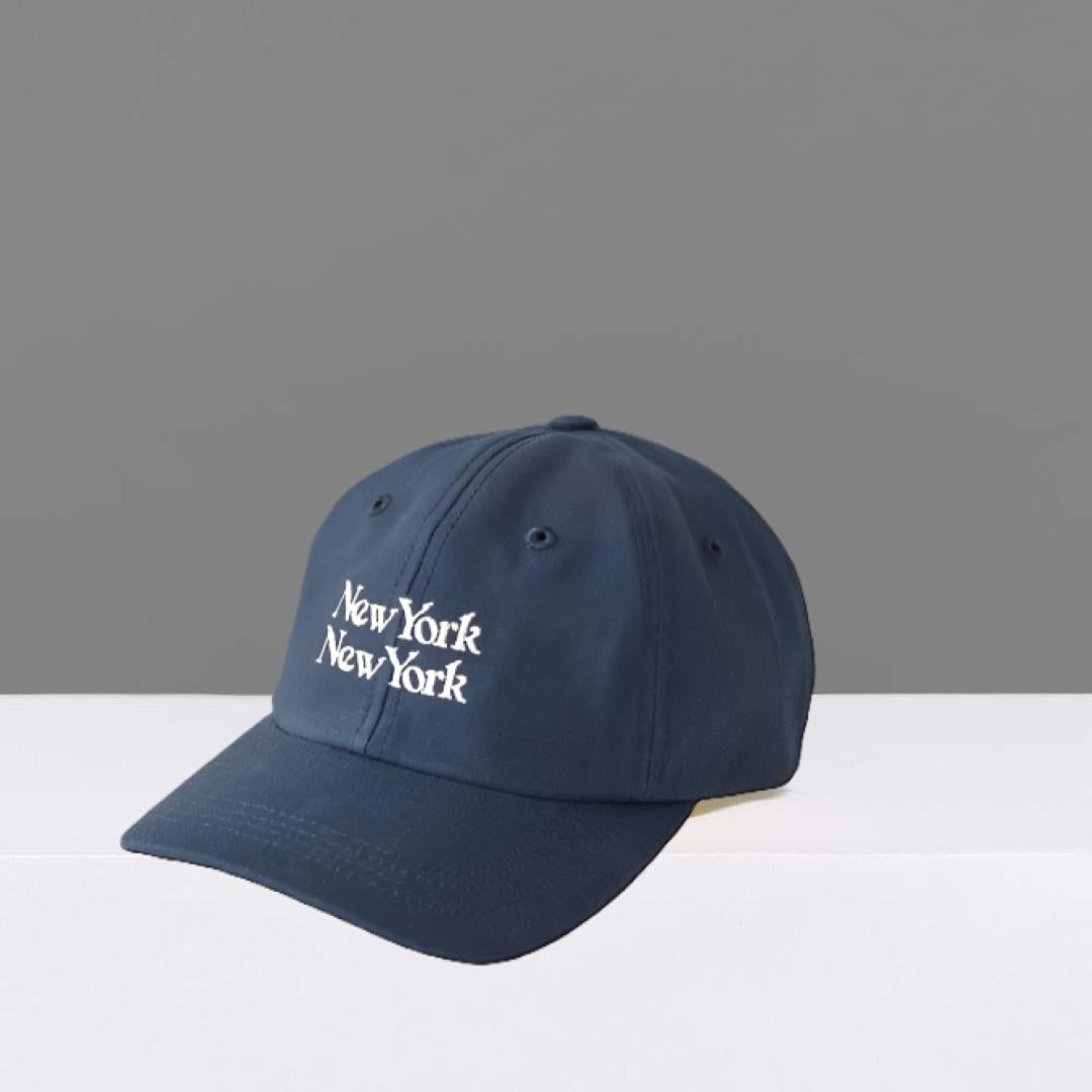 Navy blue cap with 'New York New York' text on a gray background