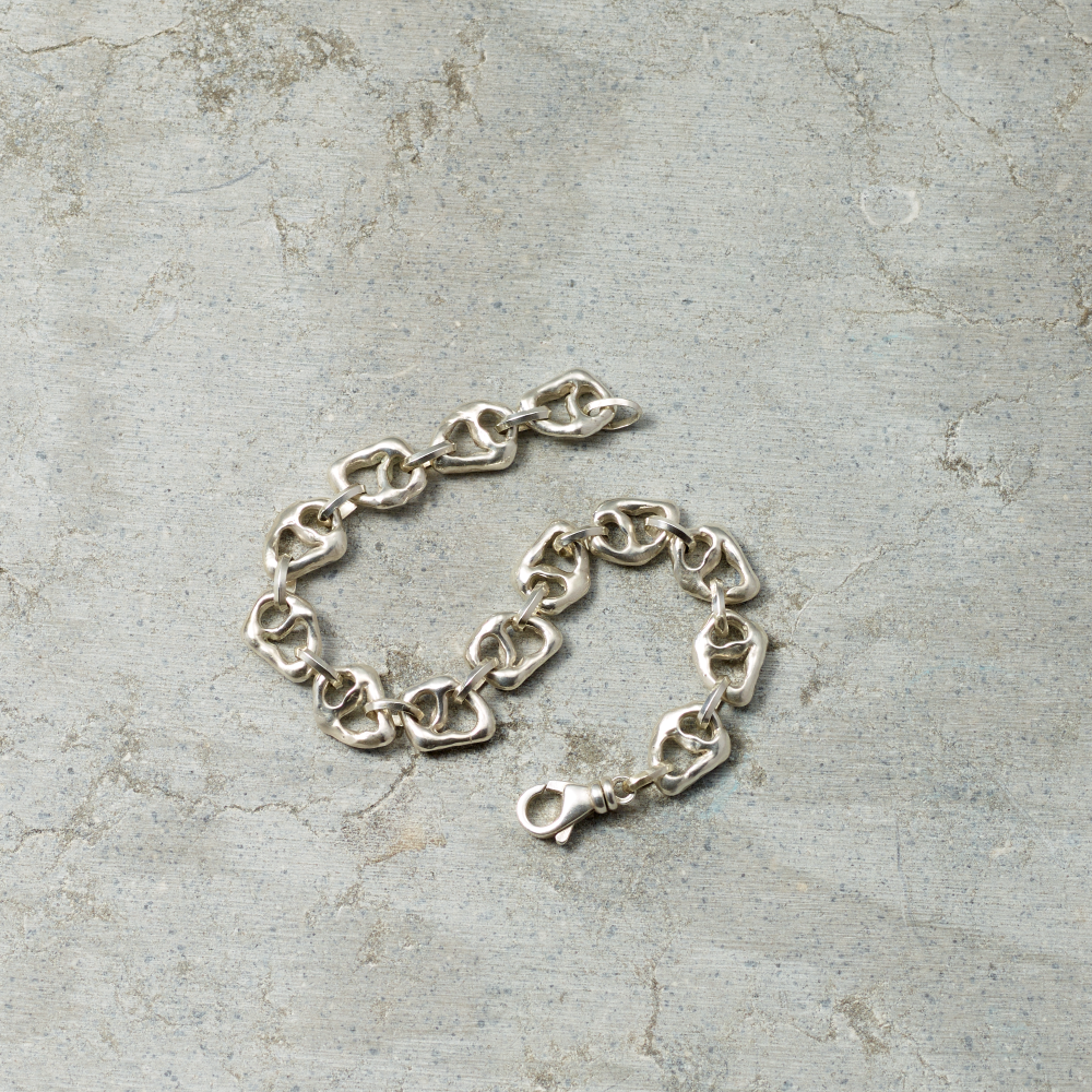 Silver chain bracelet on a textured gray surface