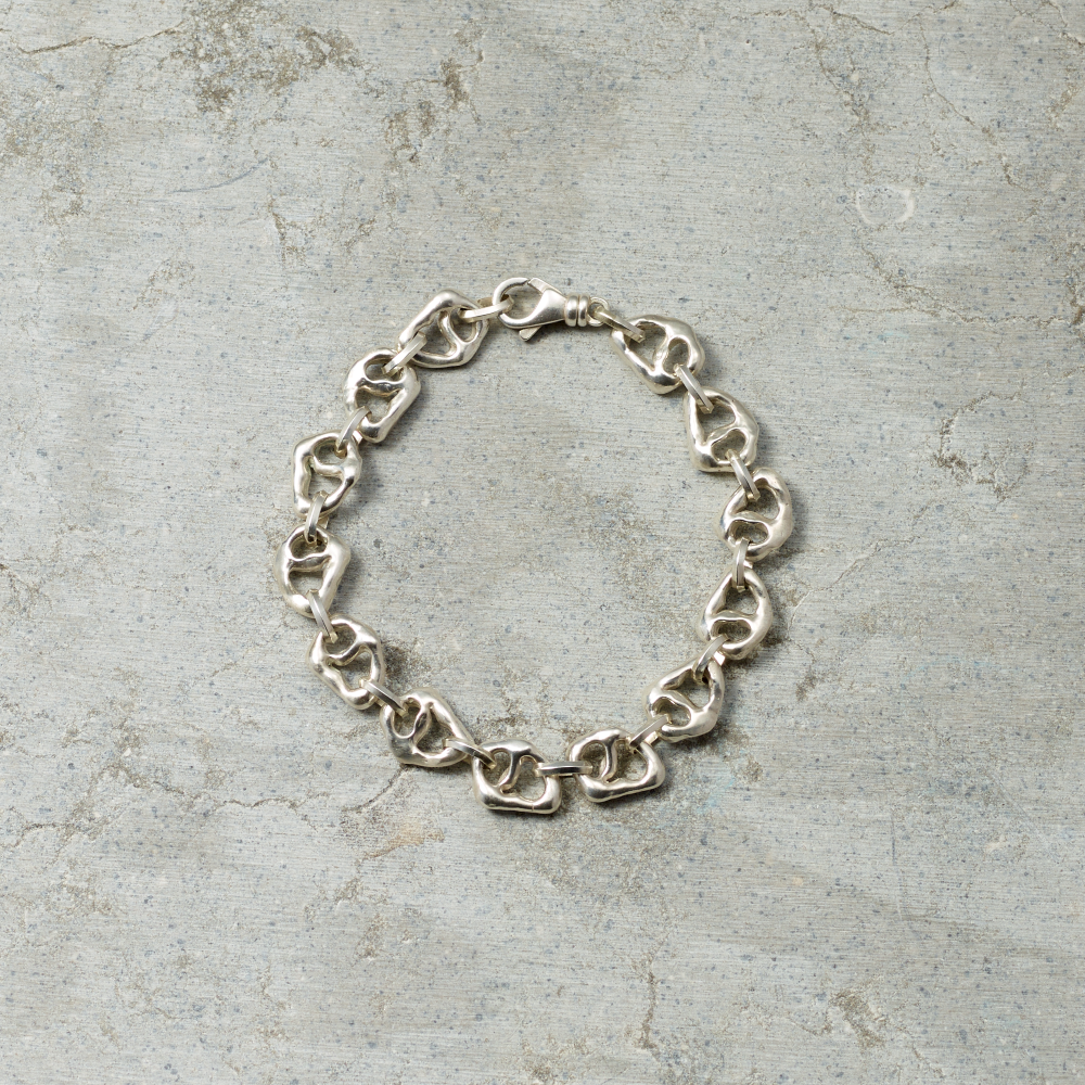 Silver chain bracelet on a textured gray surface