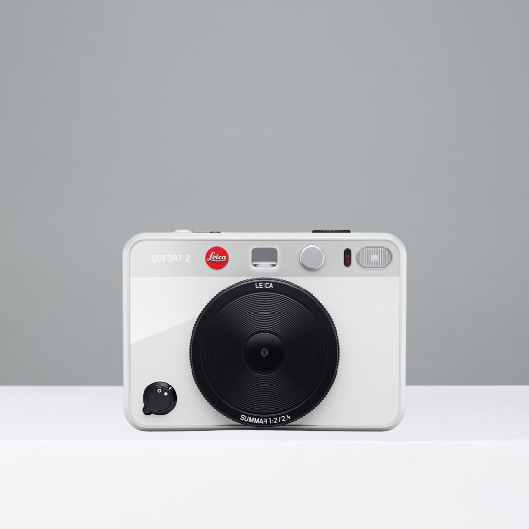 White Leica Sofort 2 instant camera on a gray background