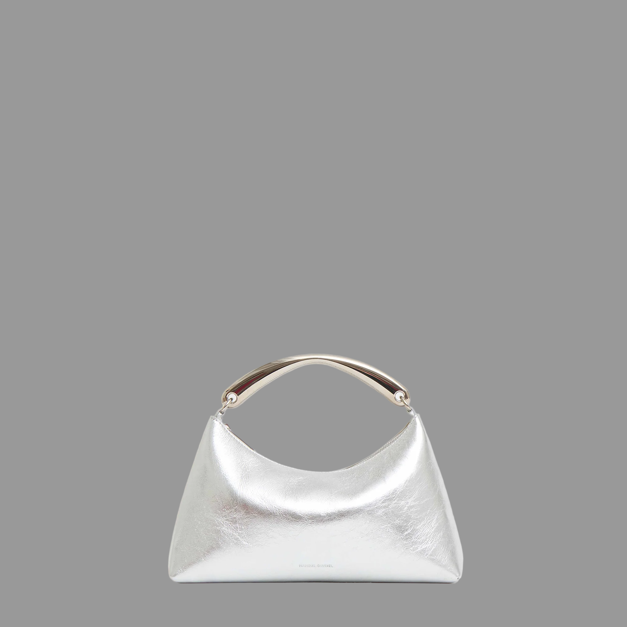 Silver handbag with silver metal handle on a gray background