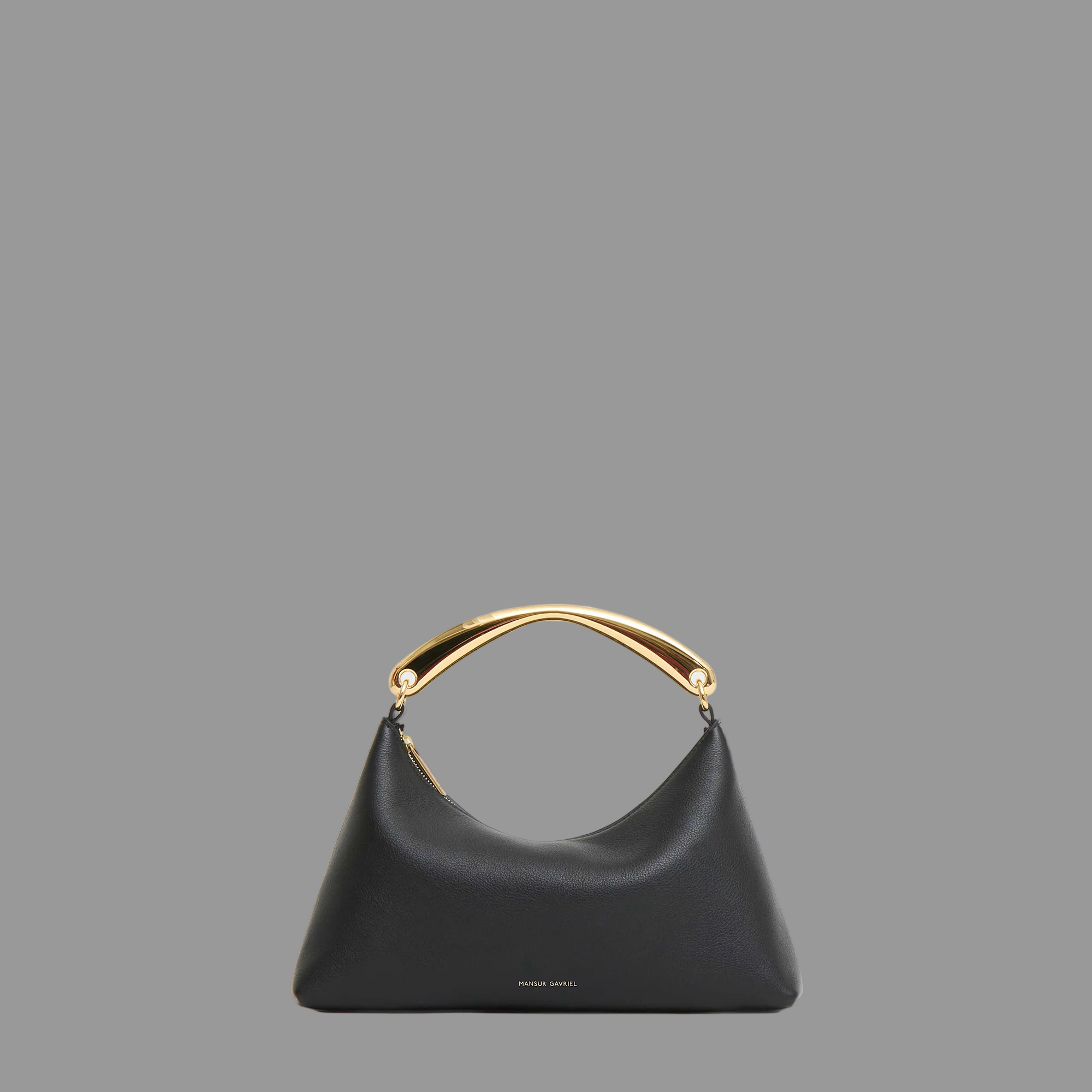 Black handbag with goldr metal handle on a gray background