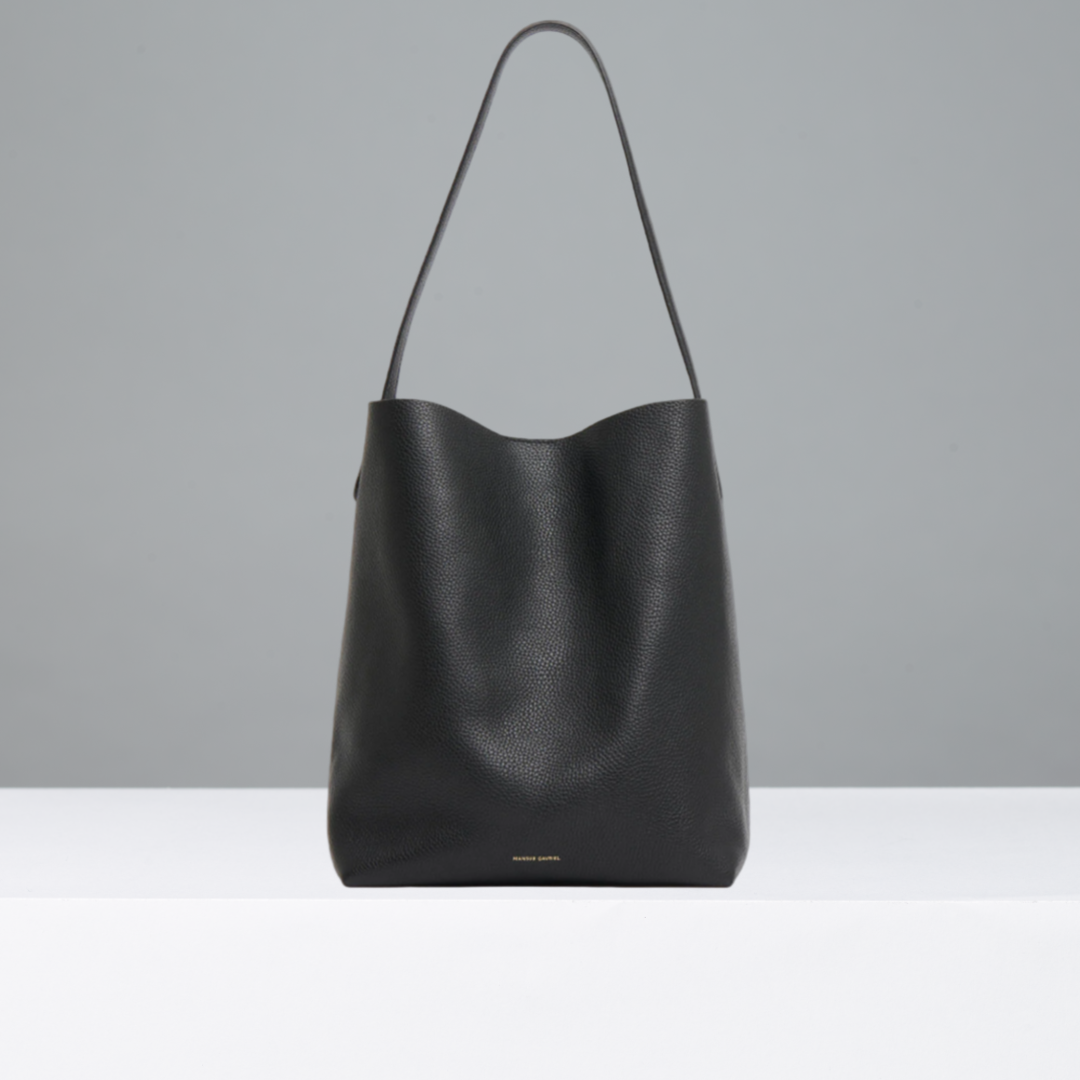 Black leather handbag on a light gray background