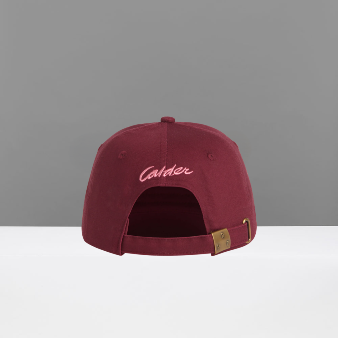 Maroon cap with 'Calder' embroidery on a gray background