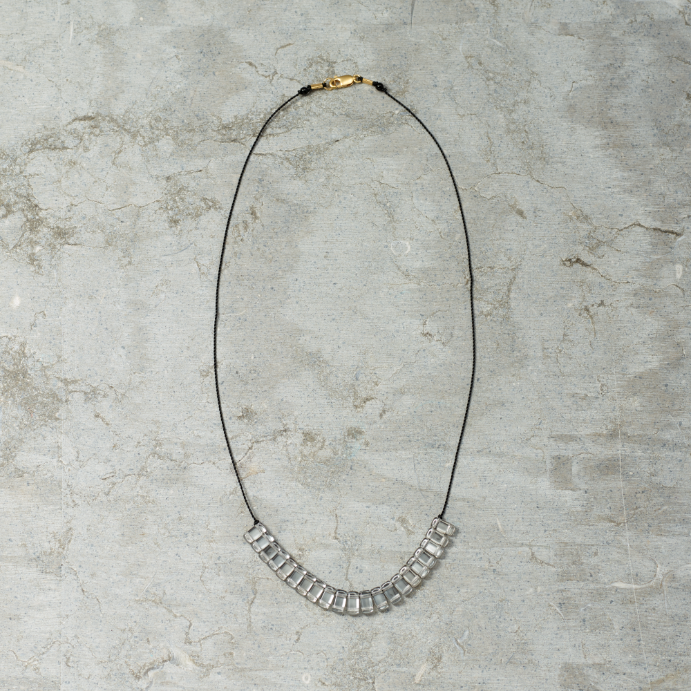 Necklace with square links on a textured gray surface