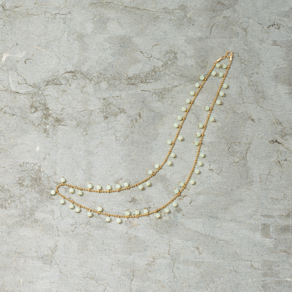 Necklace with small beads on a textured gray surface