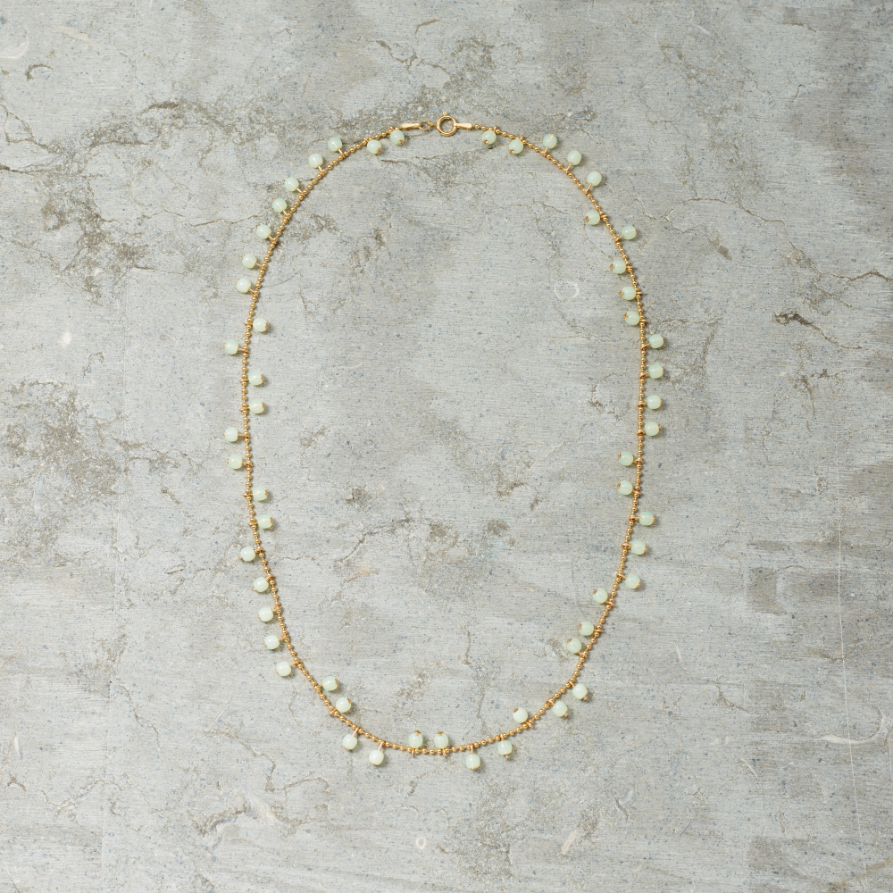 Necklace with small beads on a textured gray surface