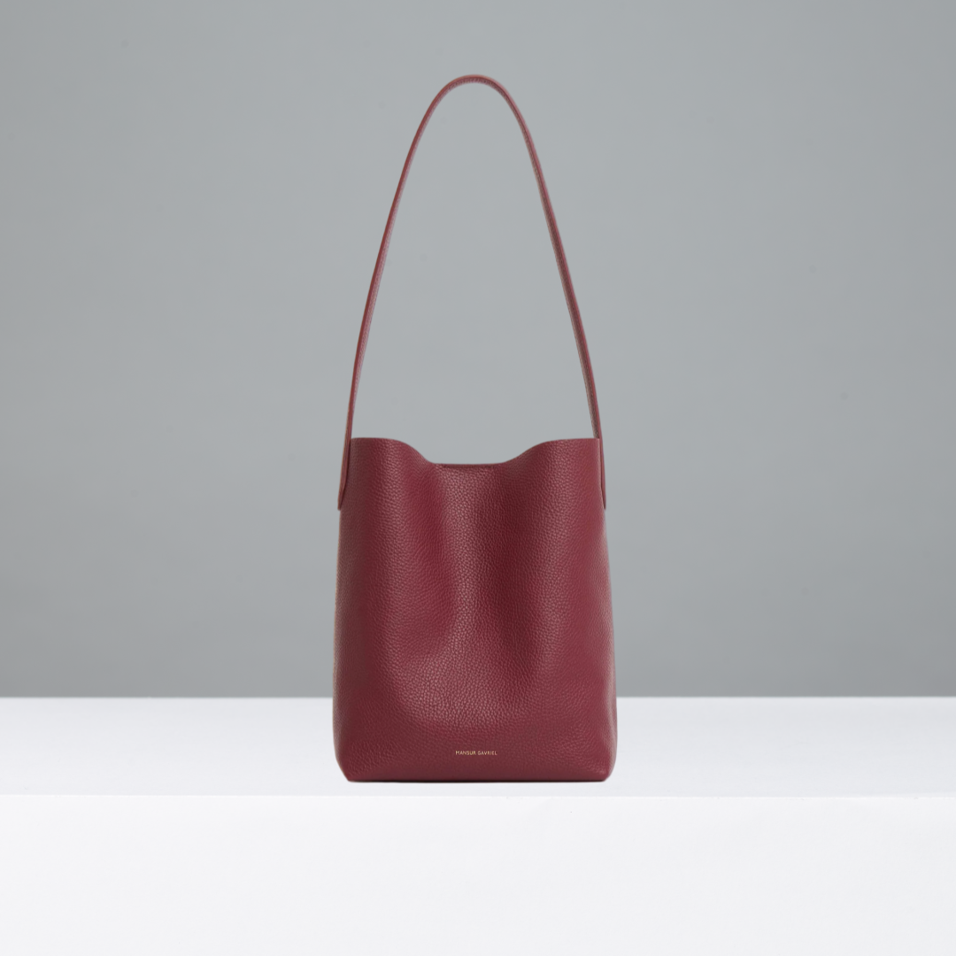 Oxblood red leather handbag on a light gray background