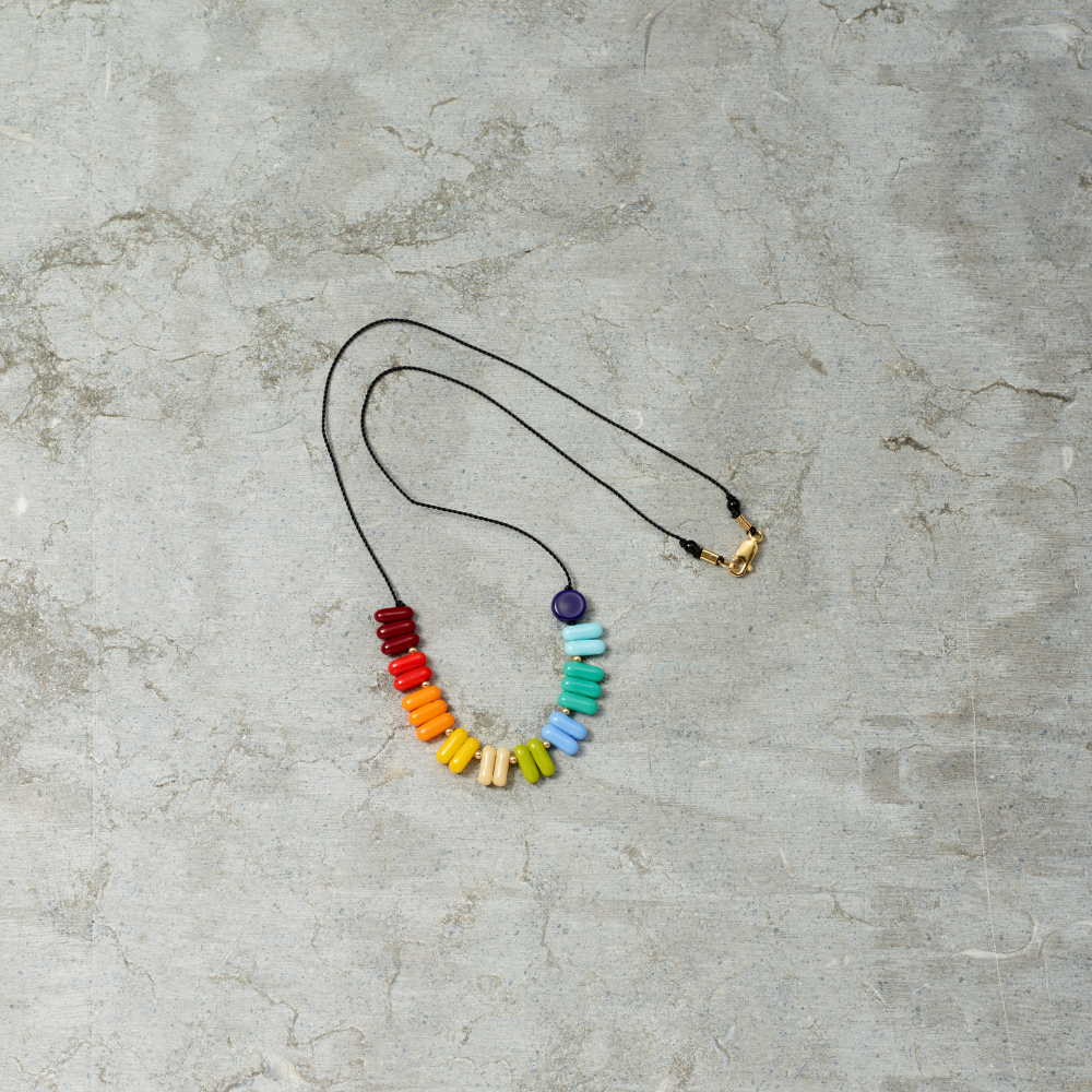 Necklace with colorful beads on a gray concrete surface
