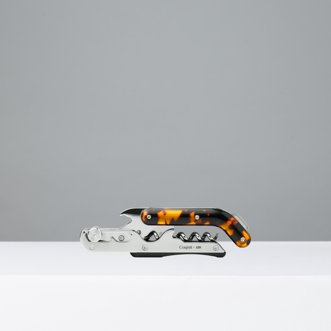 Corkscrew with tortoiseshell handle on a gray background