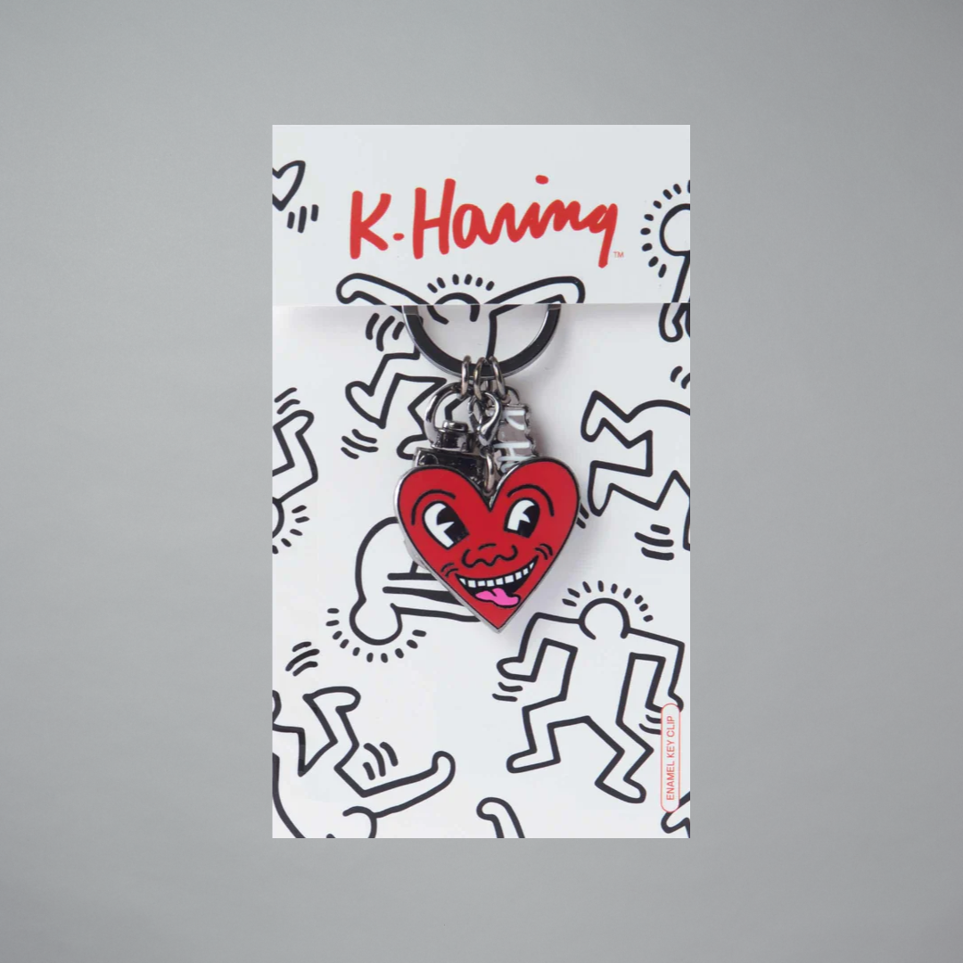 Keith Haring Heart-shaped keychain with a smiley face on a branded card