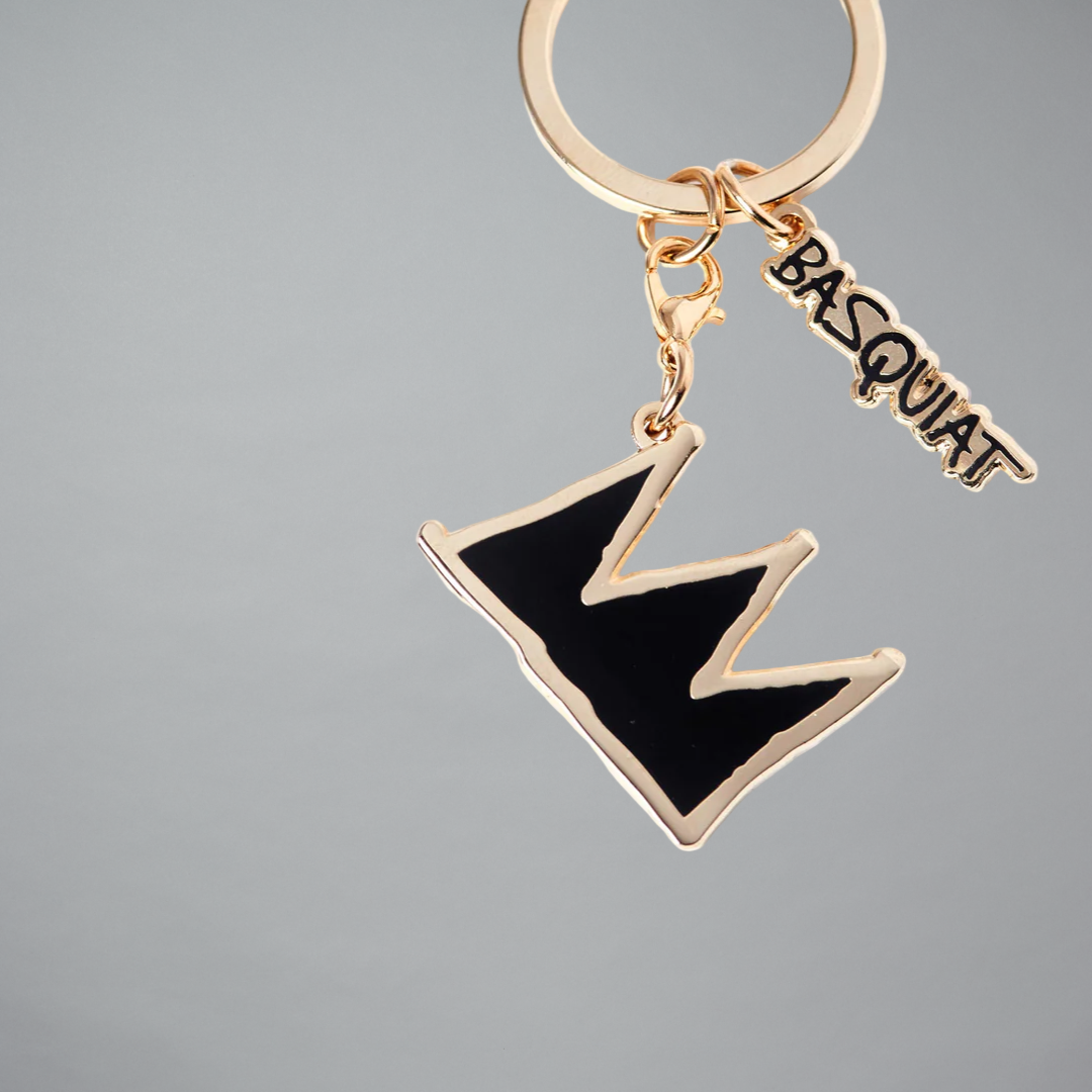 Jean-Michel Basquiat black and gold crown pin on gray background