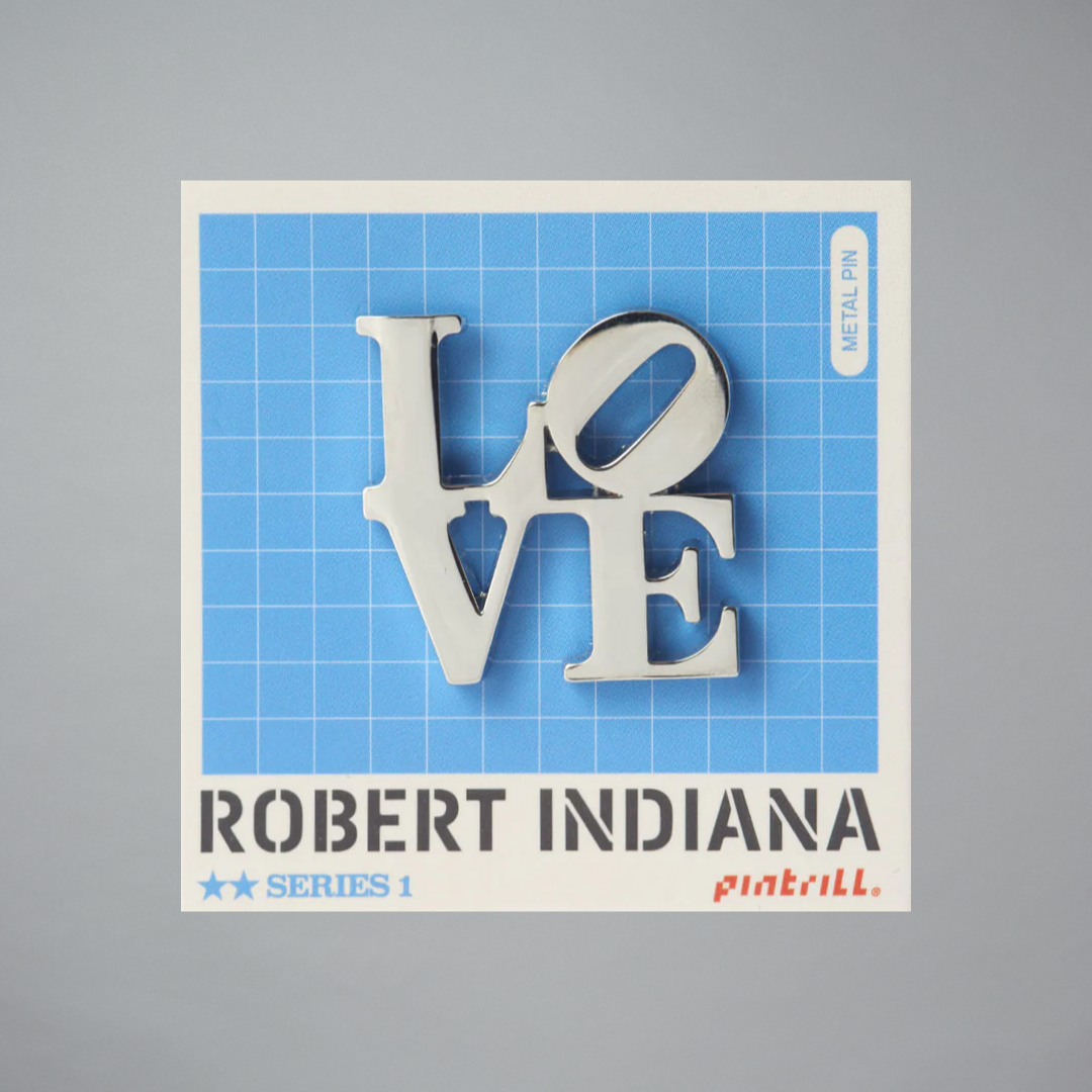 Robert Indiana Silver Love pin on a gray background