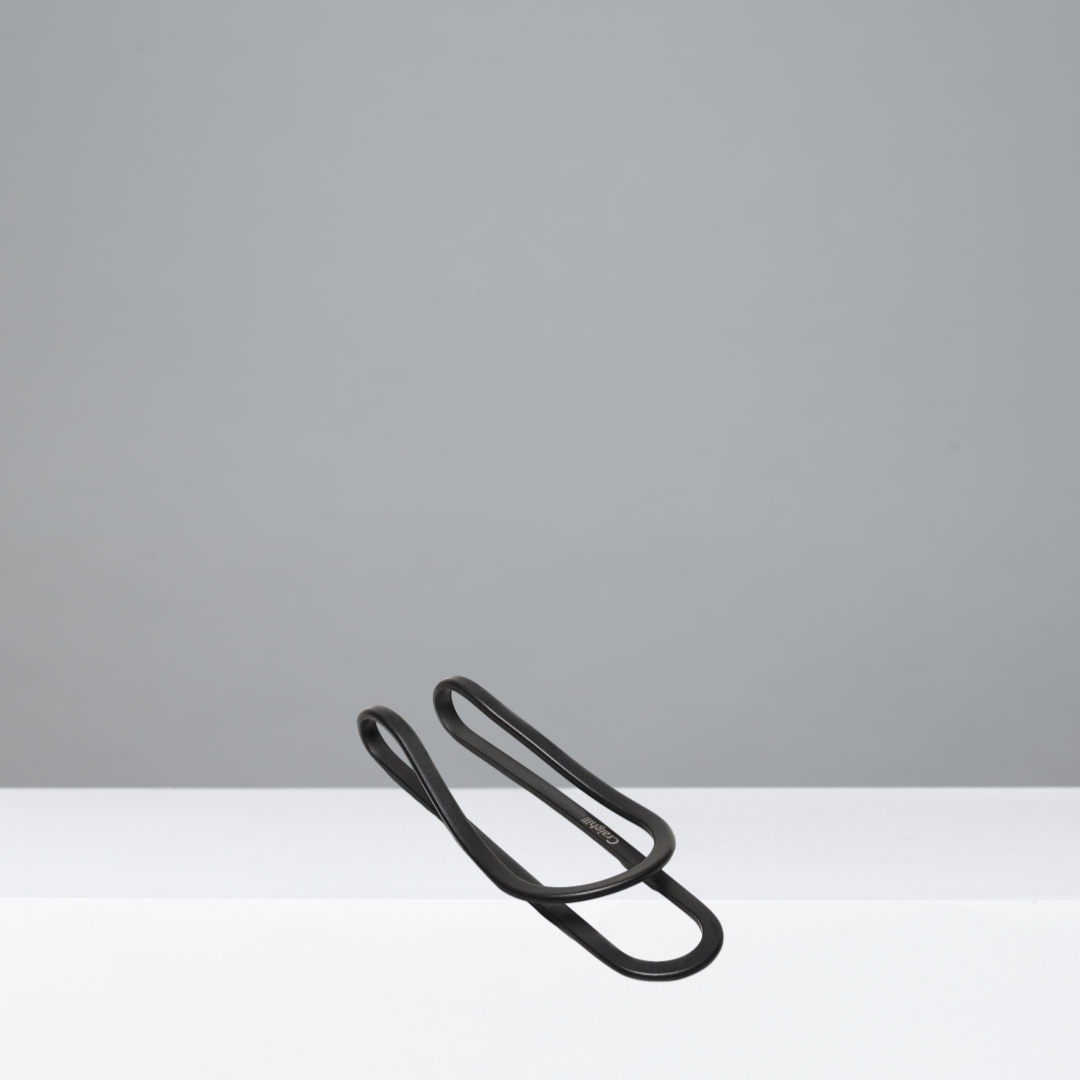 Black metal money clip on a gray background
