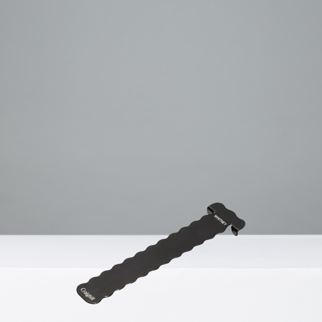 Black textured bookmark with Whitney engraved on the top on a gray background
