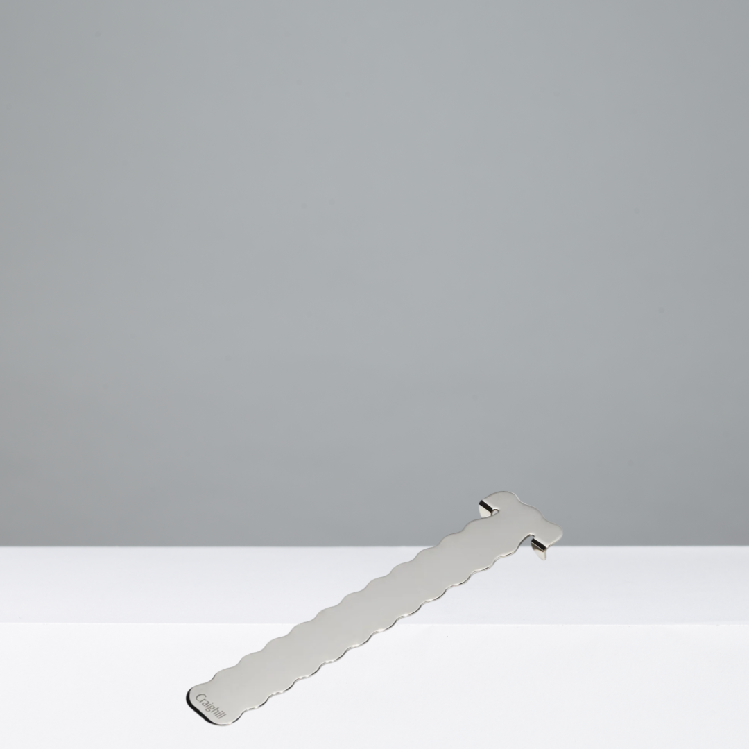 Silver bookmark with a wavy design on a gray background