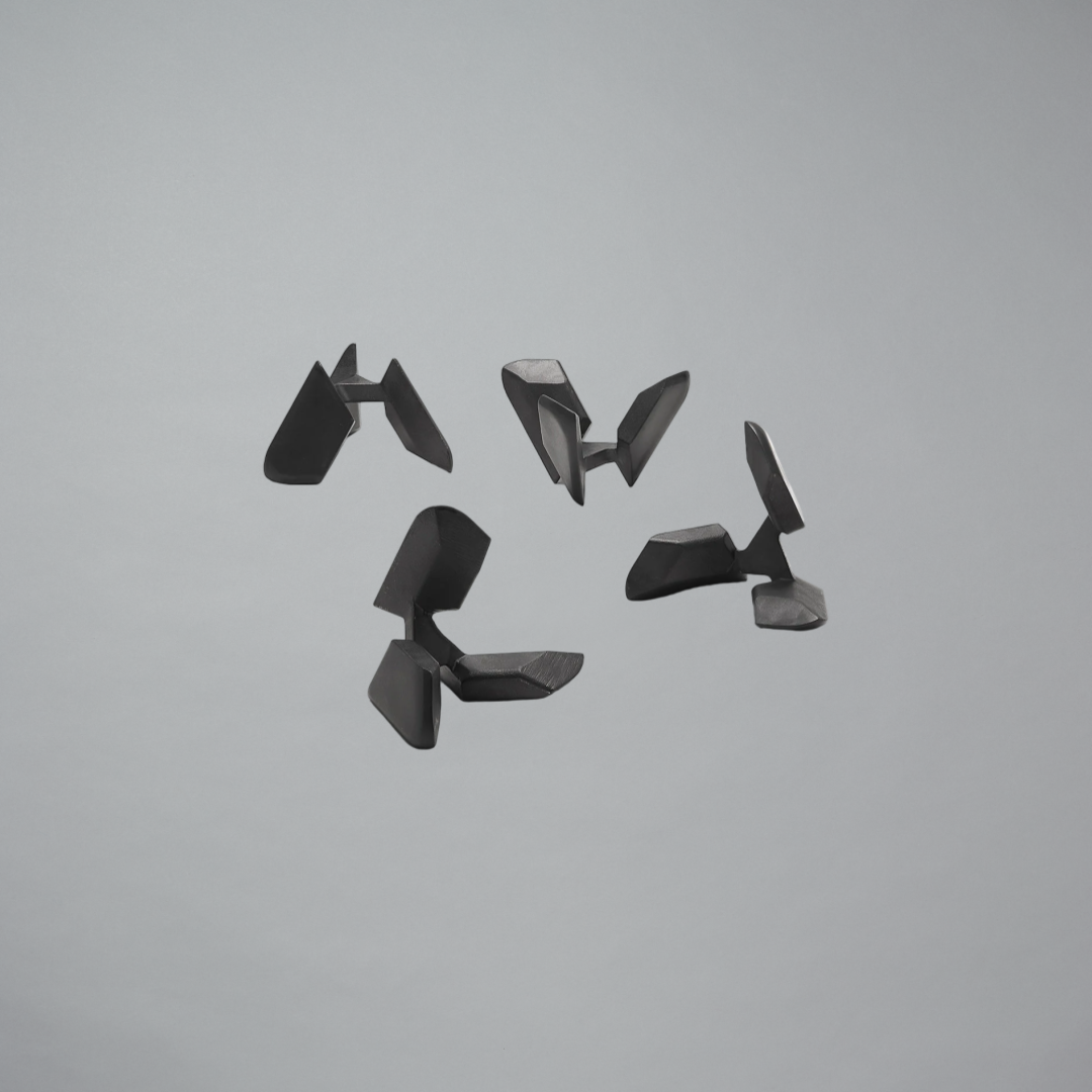 Set of four black geometric objects on a gray background