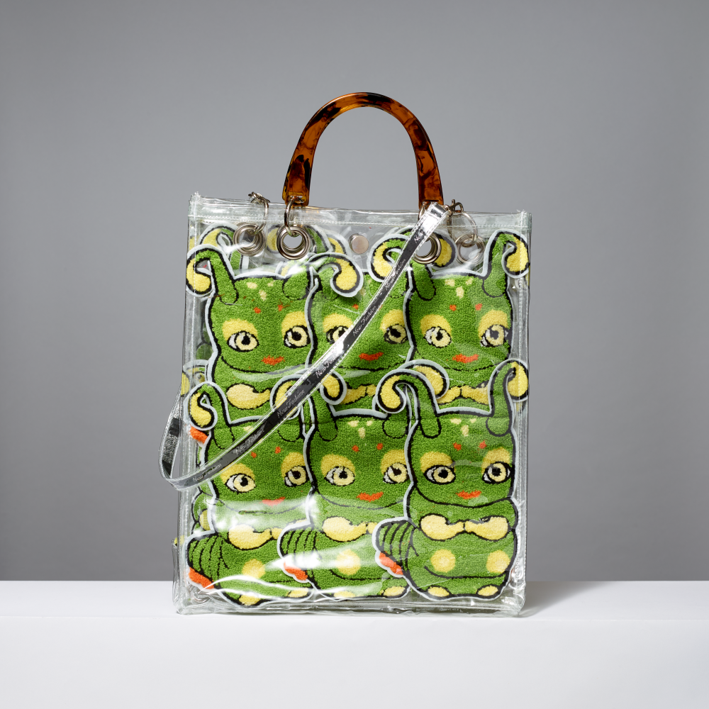 Vinyl tote bag with green caterpillar patches on a gray background