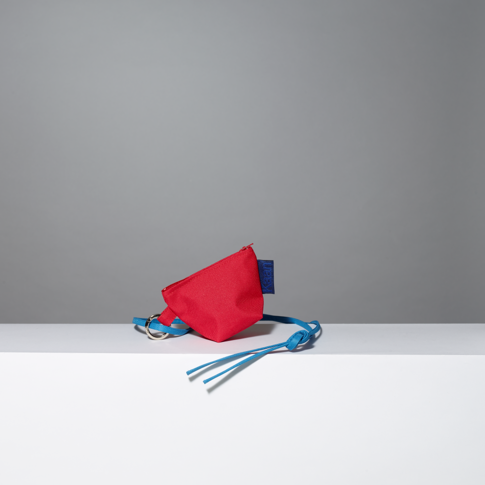 Red pouch with blue strap on a gray background