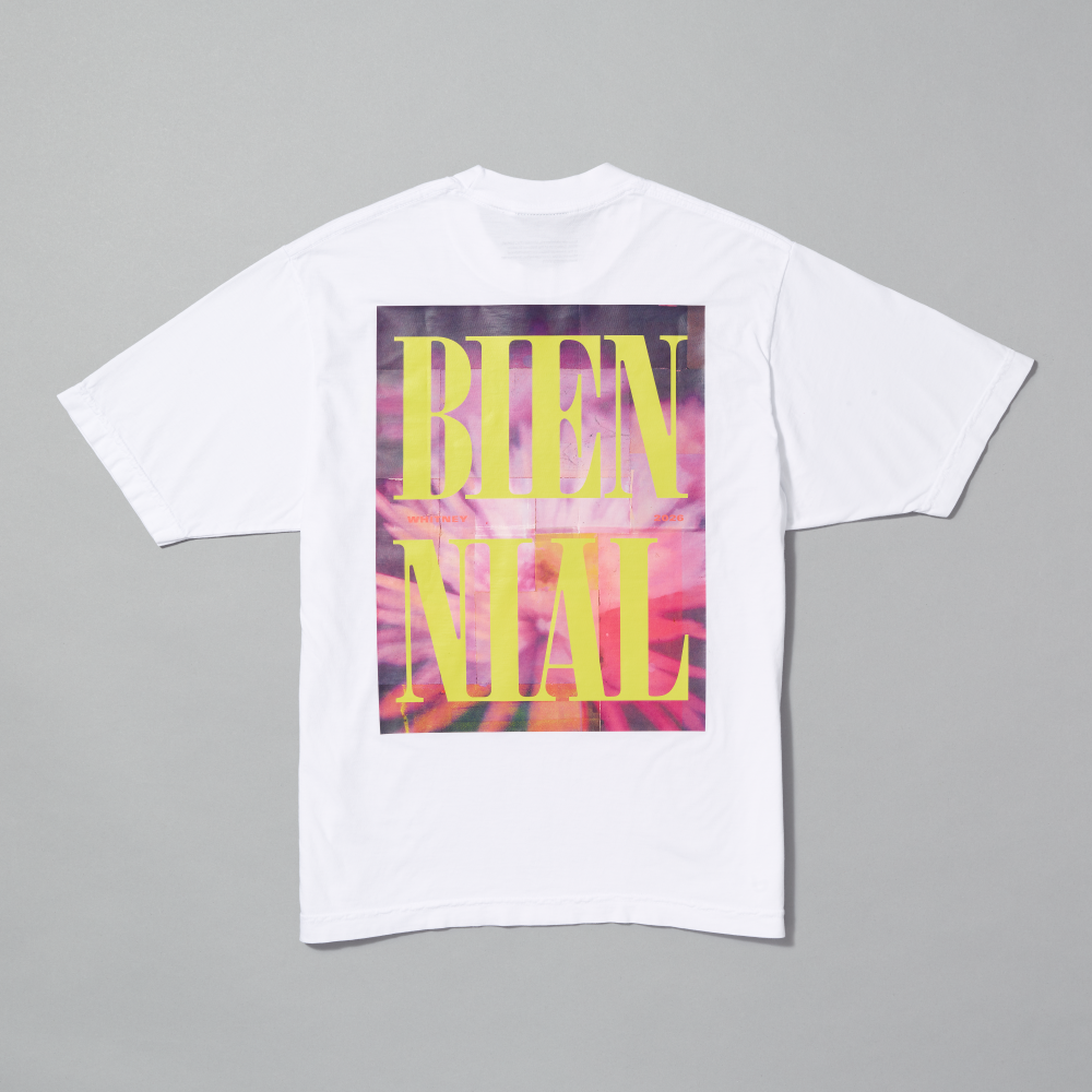 White t-shirt with colorful 'BIENNIAL' design on a gray background