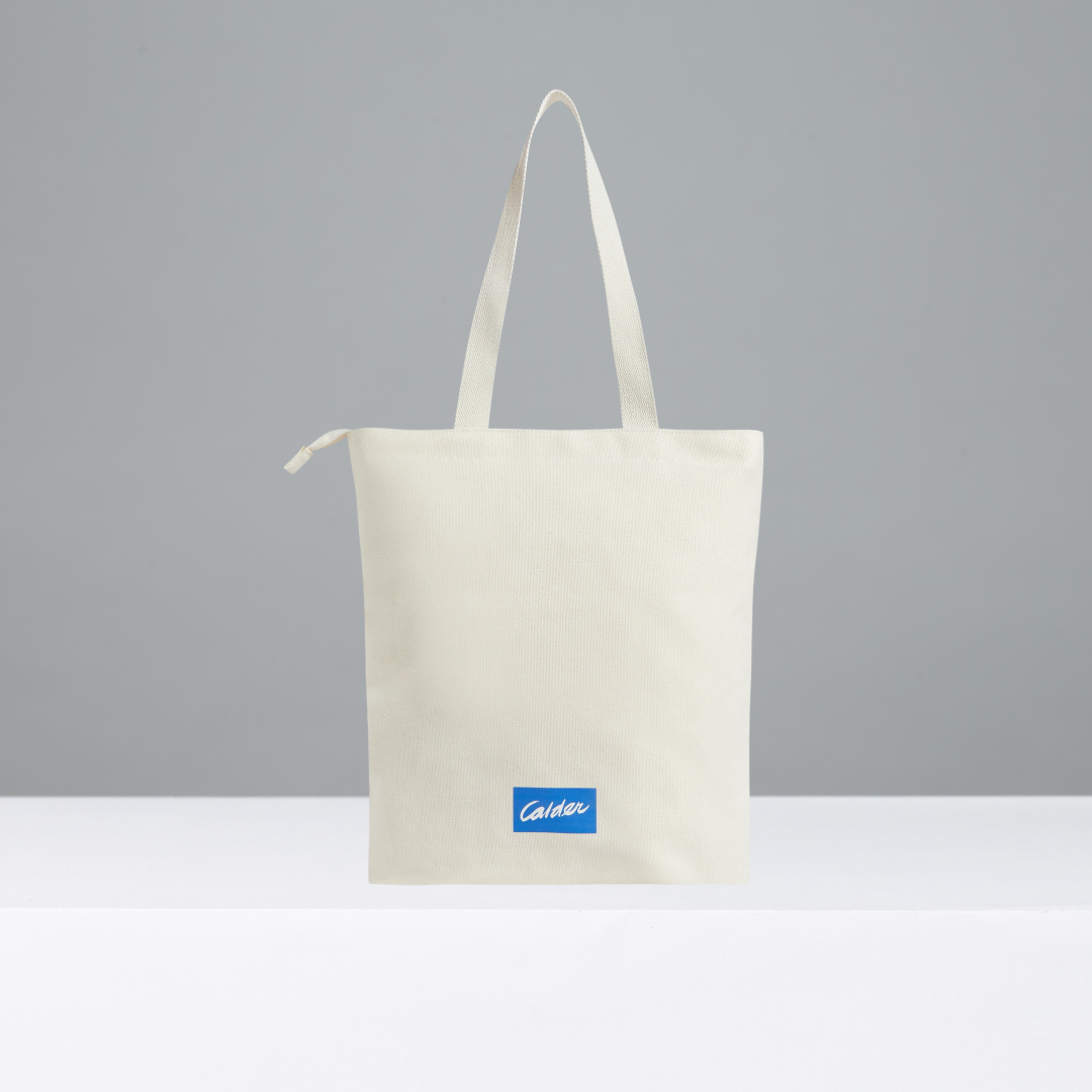 Tote bag with a blue Calder logo on a gray background