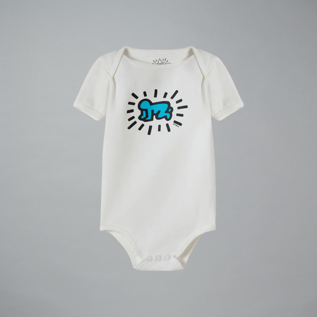 White baby onesie with blue and black design on a gray background