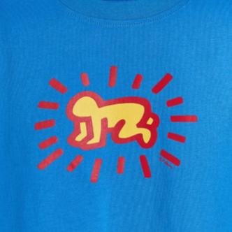 Close up of blue t-shirt featuring Keith Haring's Radiant Baby artwork