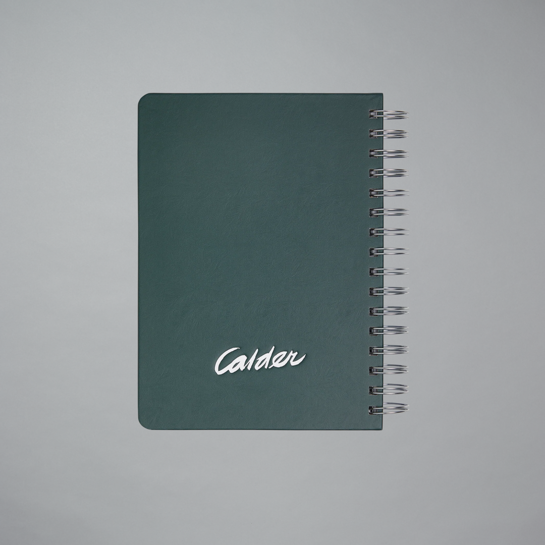 Green notebook with 'Calder' branding on a gray background