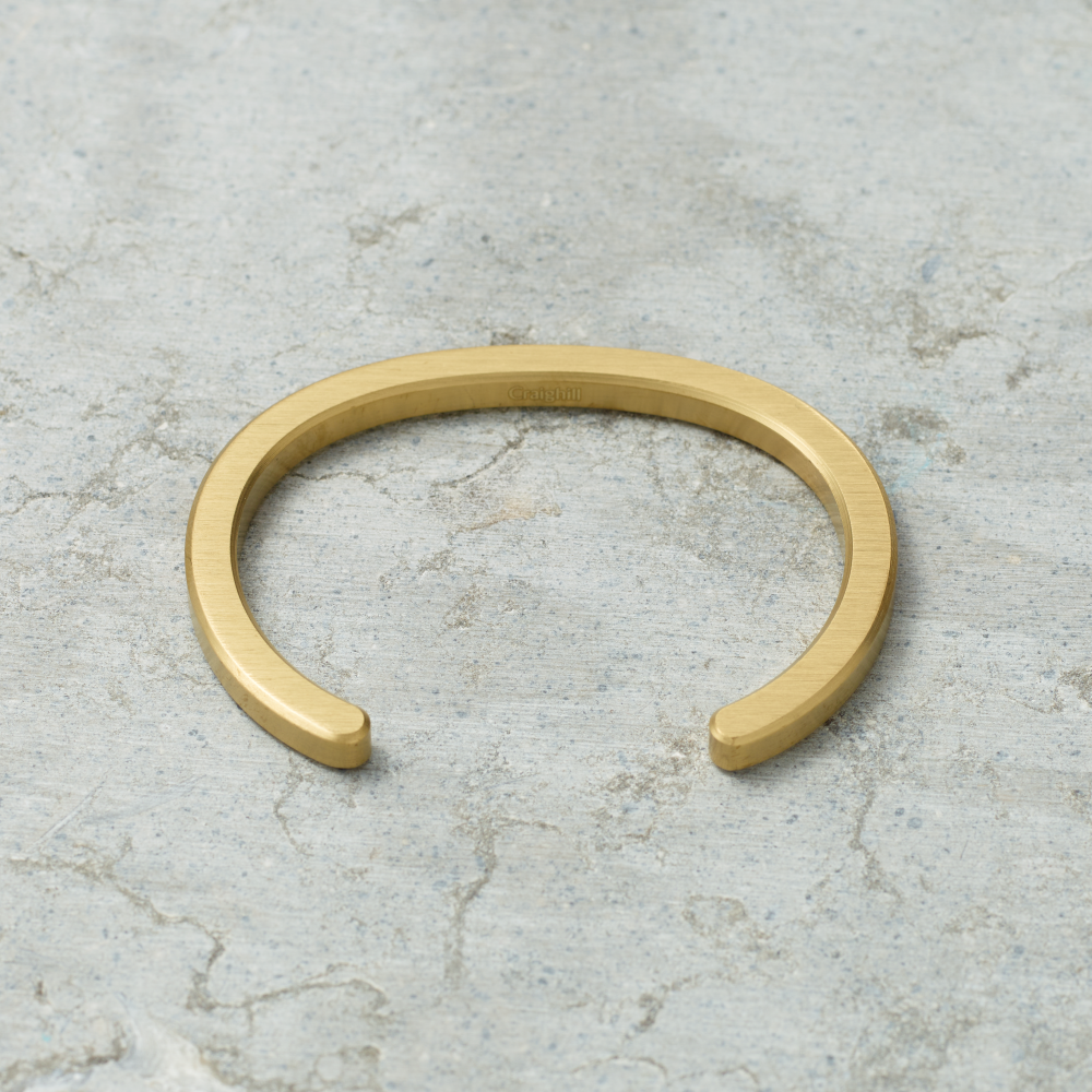 Gold bracelet on a textured gray surface
