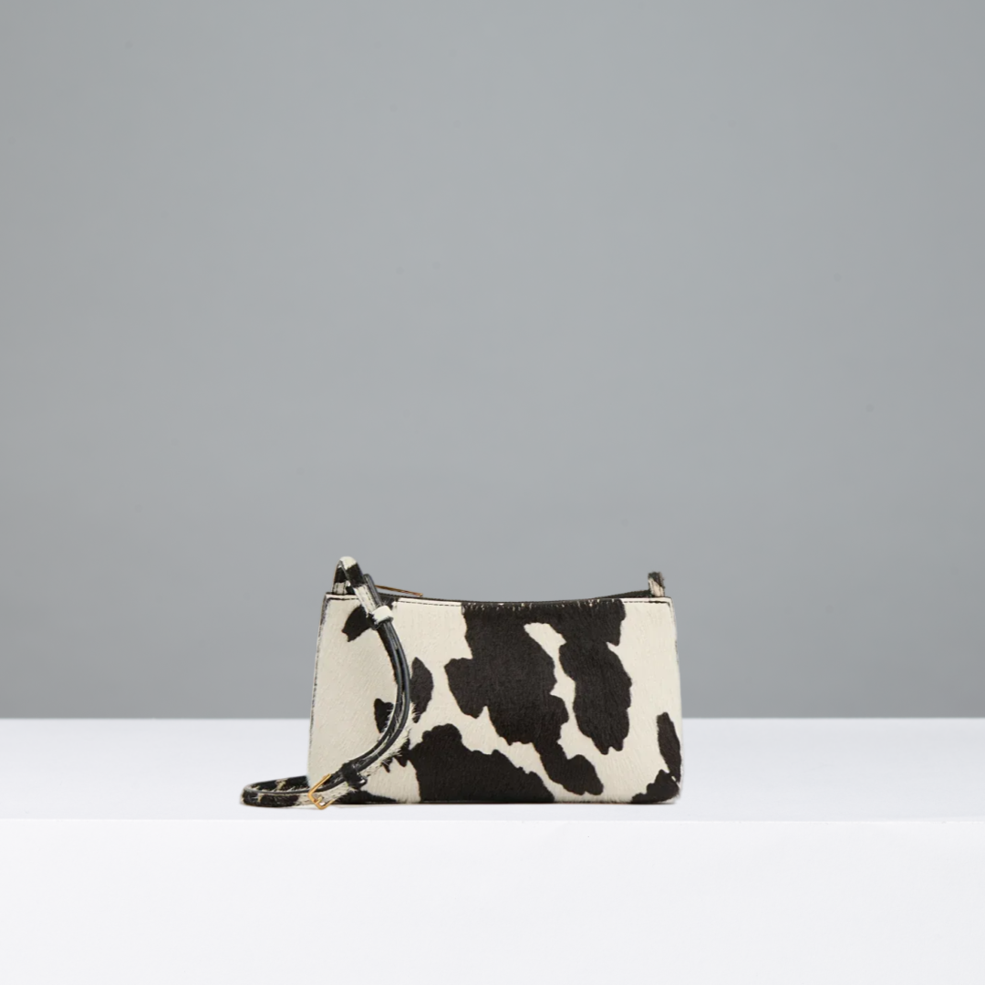 Cow print handbag on a gray background