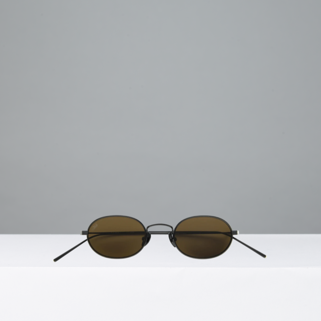 Round sunglasses with dark lenses on a white surface with gray background