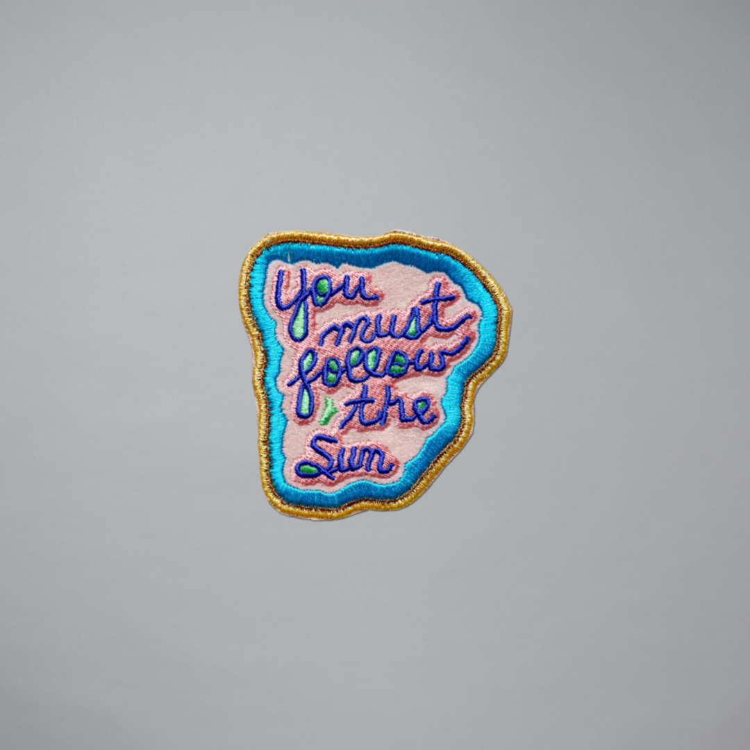 Embroidered patch featuring You Must Follow the Sun by Jeffrey Gibson