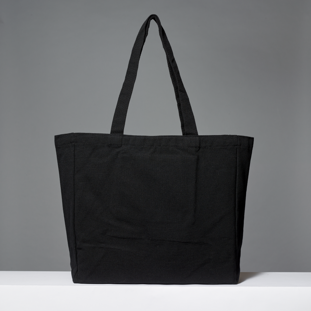 Black cotton tote on a white ledge against a gray background