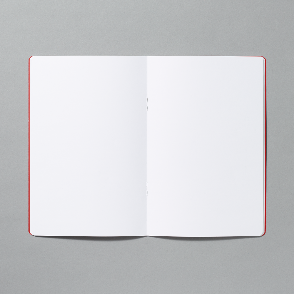 An open blank notebook with blank white pages photographed from above on a smooth gray background.