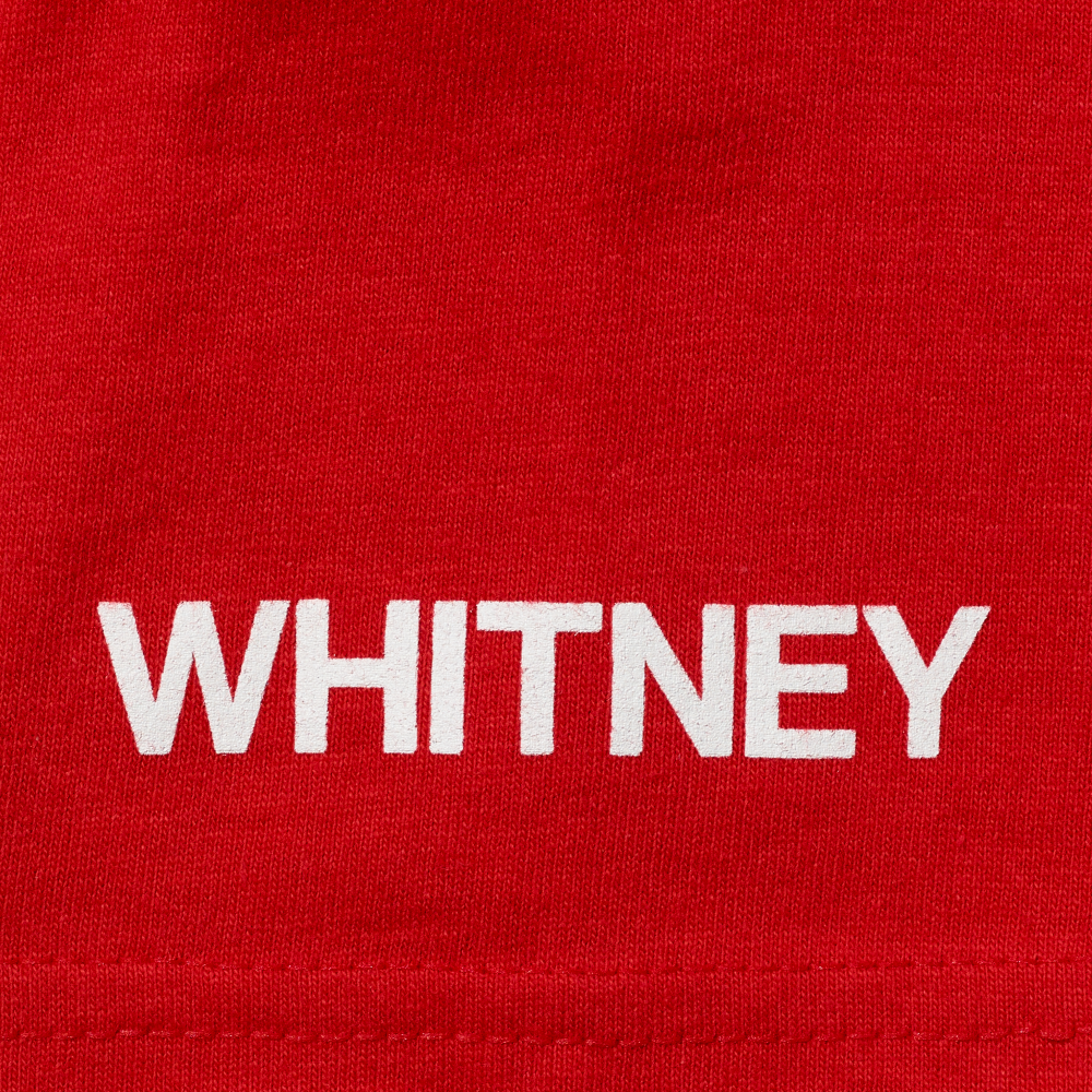 Whitney in white screen printed onto the sleeve of a red t-shirt