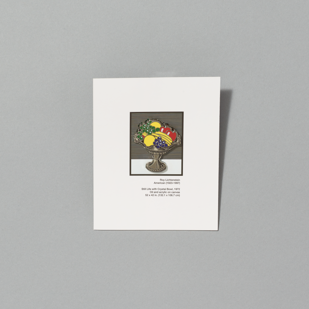 Enamel pin featuring Still Life with Crystal Bowl by Roy Lichtenstein on white cardboard packaging on a gray background